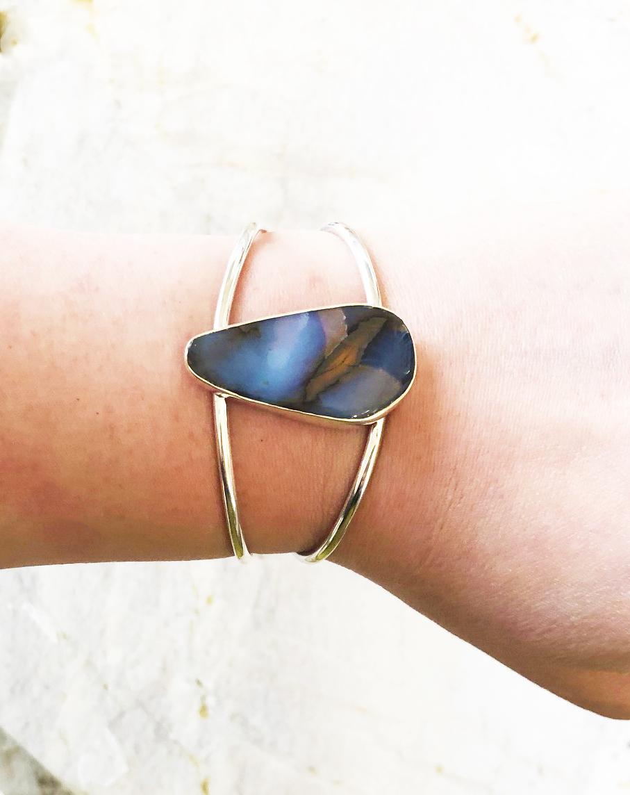 Gorgeous bracelet made with a a superb Boulder opal natural teardrop shaped cabochon (38mm long  x 20mm wide at its widest point) bezel set in sterling silver and mounted on a split shank sterling silver cuff. This gorgeous bracelet has a flexible