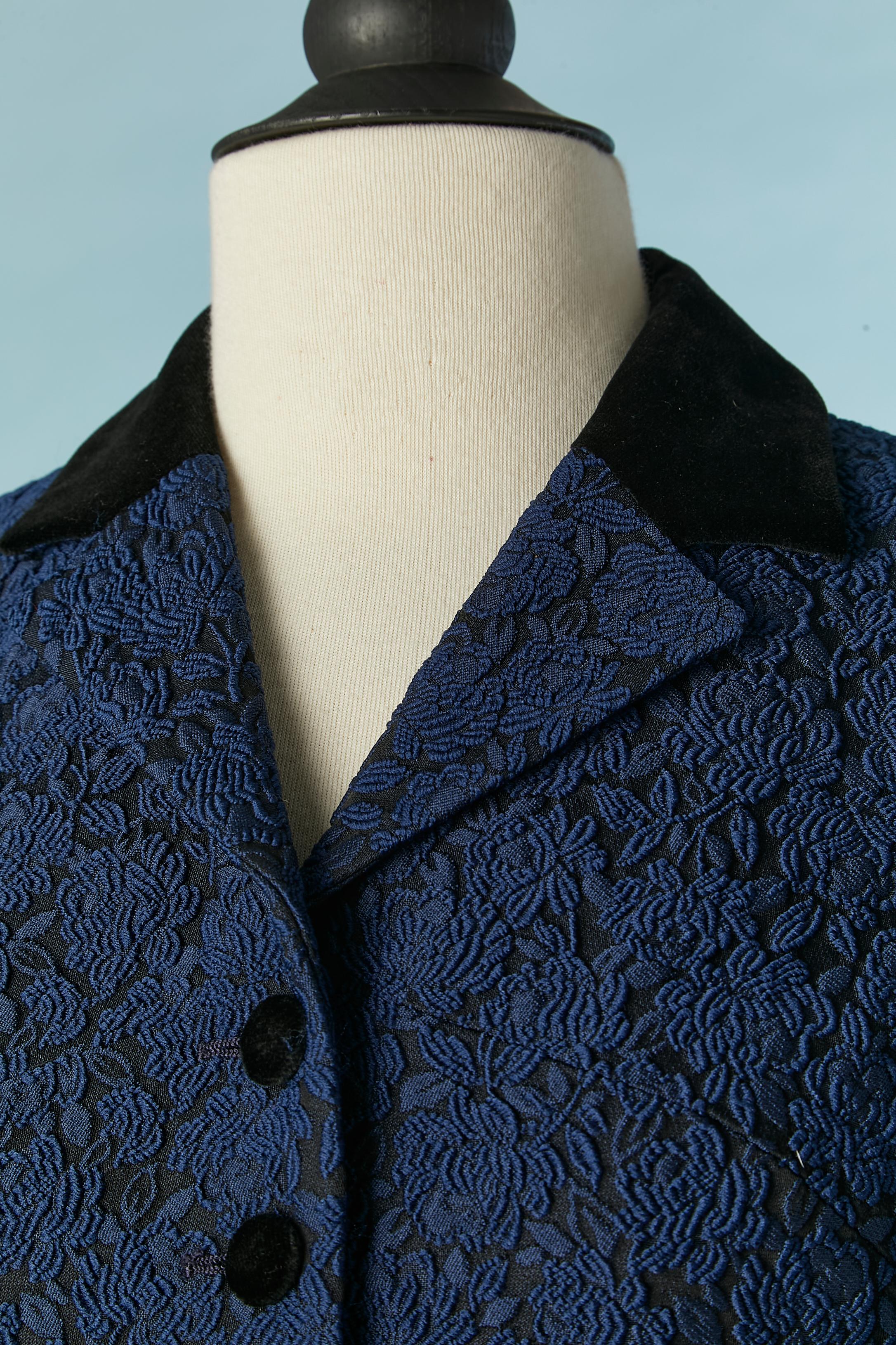 Tailleur jupe en brocart bleu avec détails en velours noir. 
Composition du tissu principal : 55 % polyester, 31 % acétate, 14 % acrylique. 
Doublure en rayonne. Découpage. 
TAILLE 40 (It) 36 (Fr) 6 (Us) S 