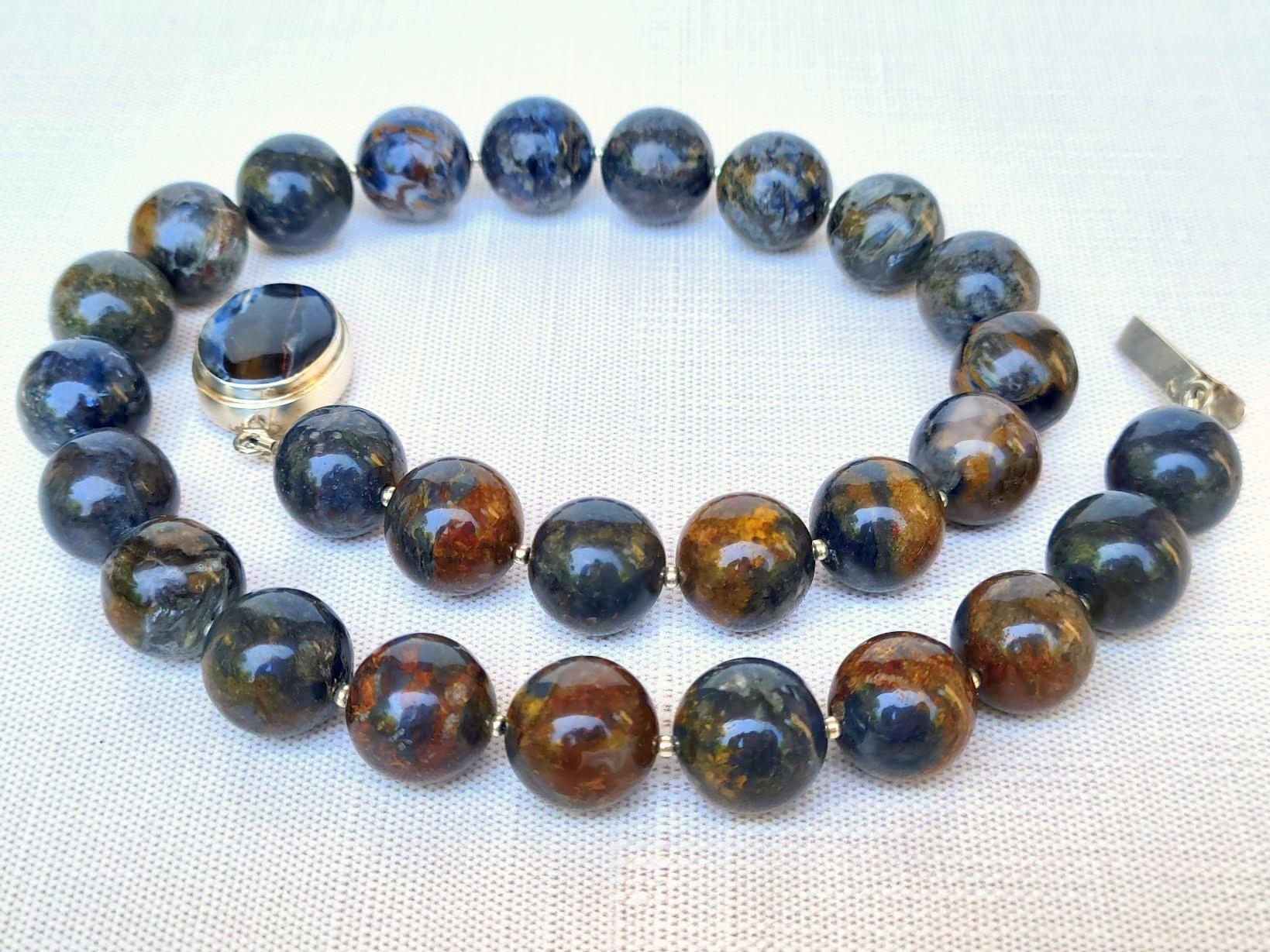 La collana è lunga 18,5 pollici (47 cm). La dimensione rara delle perle rotonde lisce è di 15 mm.
Le perle sono rare, di ottima qualità e di colore unico. Hanno deliziose tonalità marrone-blu, rosso-blu, grigio-blu e oro-blu e una struttura setosa.