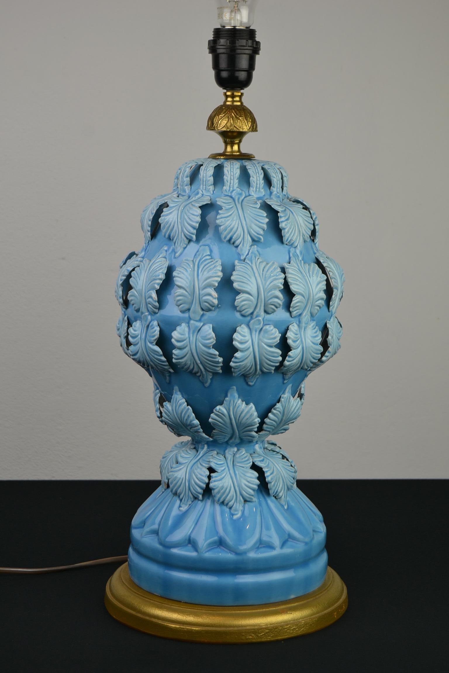 Blue ceramic table lamp with leaves by Ceramics Manises Spain. 
This light blue - turquoise ceramic table lamp has beautiful leaves all around 
and is mounted on a gilded wooden base. 
A blue lacquer or blue glazed sculptural ceramic table light