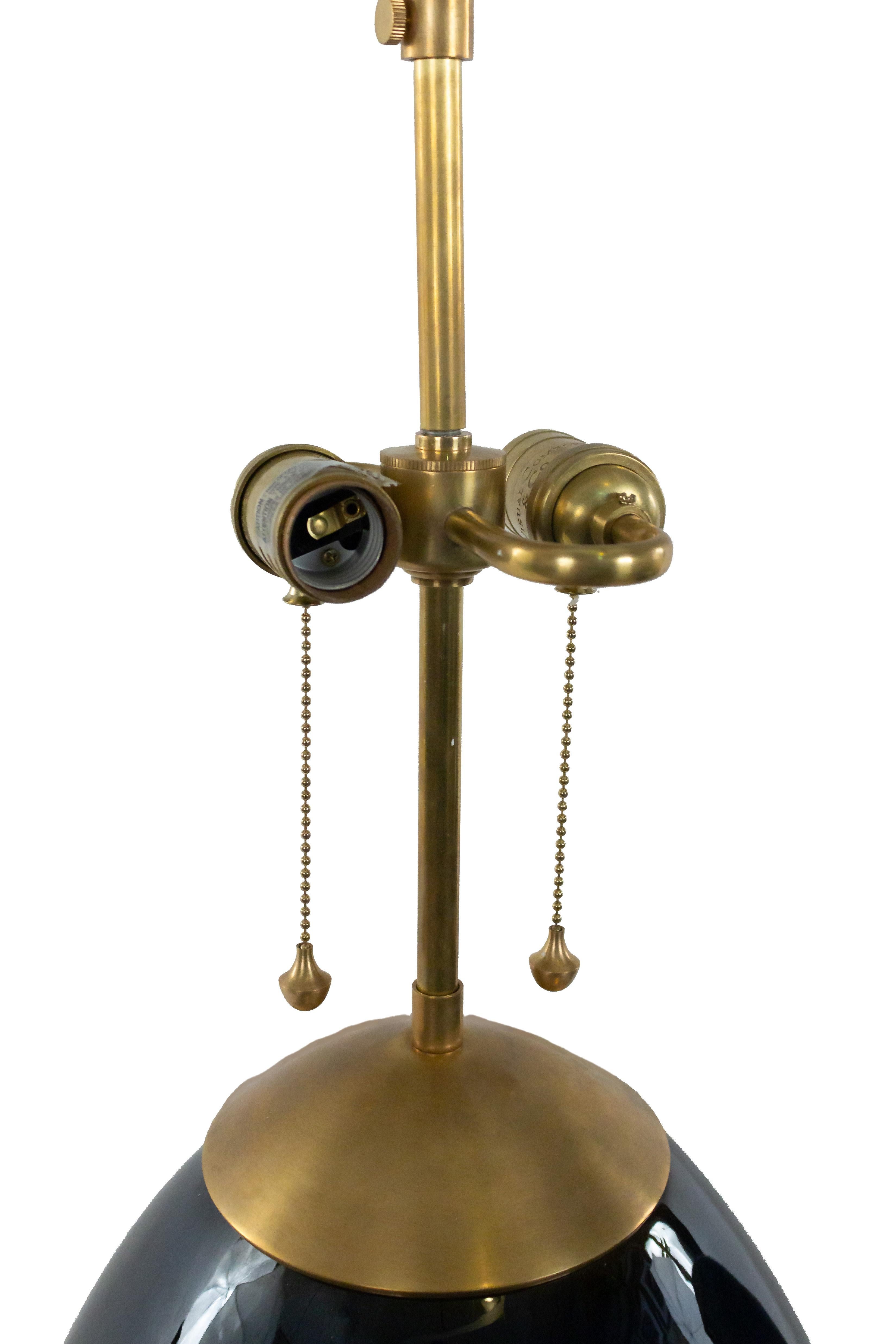 Contemporary navy bulb-shaped ceramic lamp with antique brass square base and hardware. (Contemporary Wiring).
 