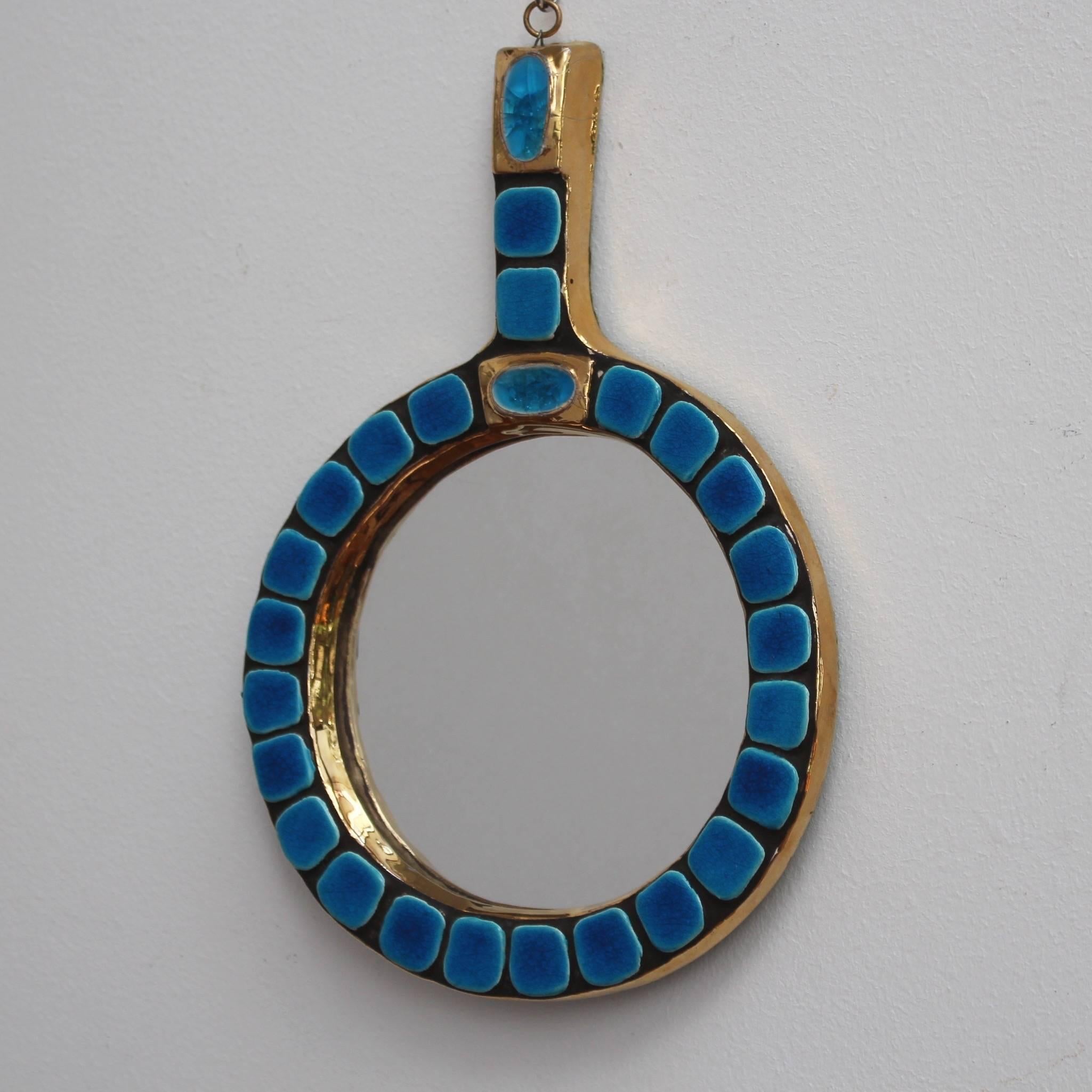 Ceramic tiled circular hand mirror by Mithé Espelt (circa 1970s). An elegant piece of decorative art on a golden glazed ceramic frame with surrounding blue glazed tiles. An azure enamel piece with gold surround sits in the base of the mirror's