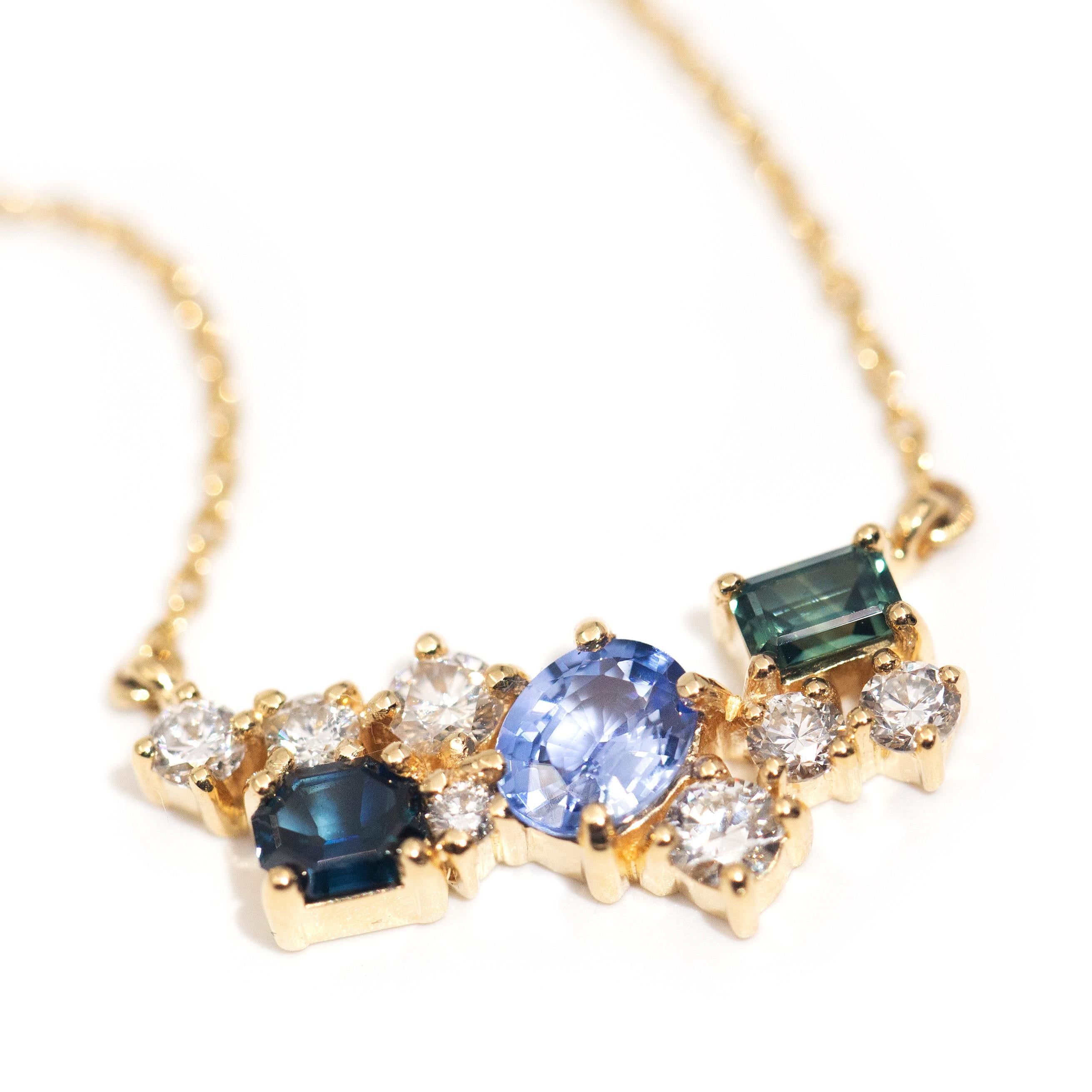 Forged in 18 carat yellow gold, this elegant contemporary necklet is an exquisite delight with her gorgeous diamonds alluring bright blue Ceylon sapphire flanked by a pair of Australian emerald cut sapphires. We have named this graceful adornment
