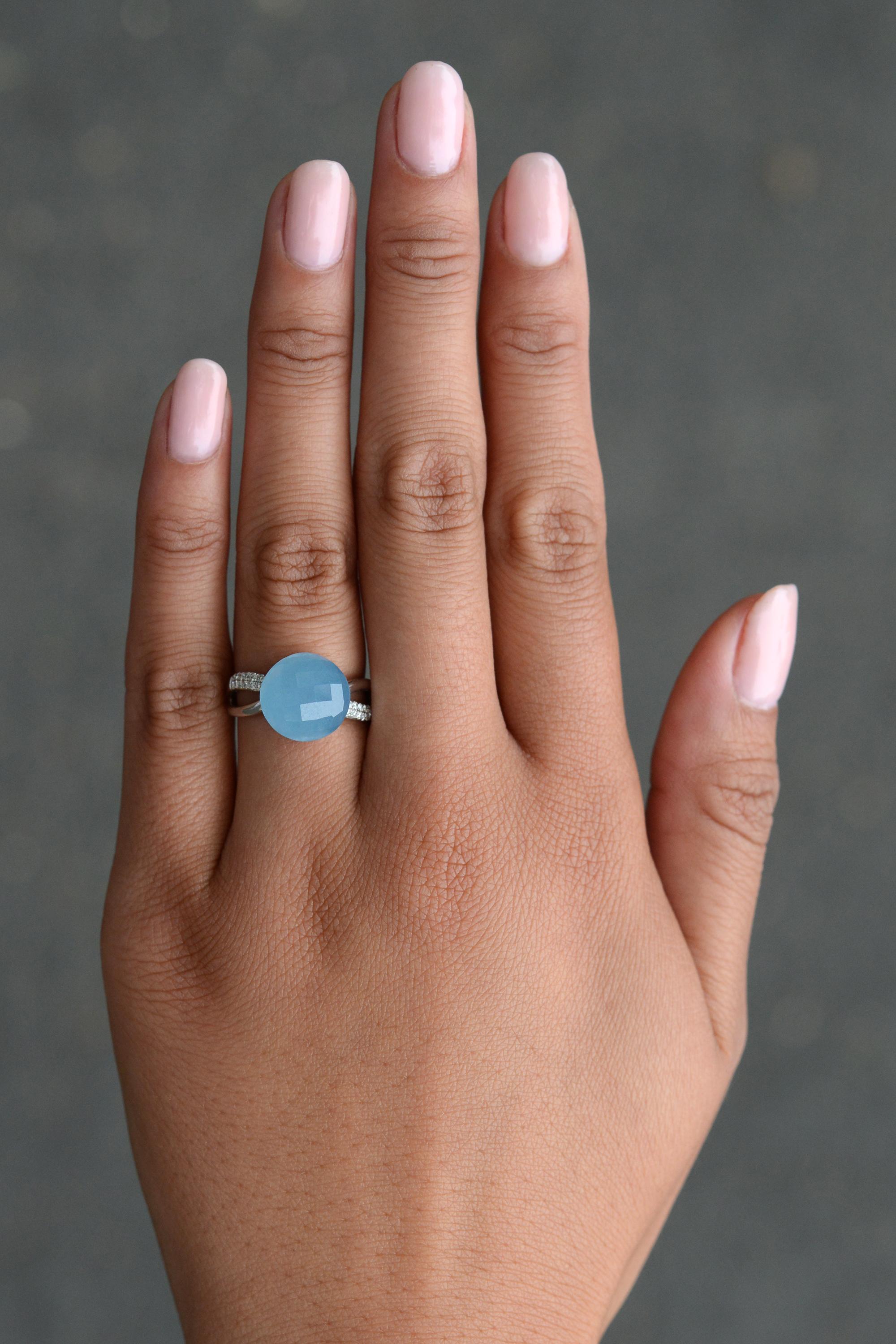 A spectacular contemporary dome ring uniquely handmade in 14k white gold featuring a natural, icy-blue chalcedony faceted cabochon embellished with 24 shimmering diamond accents. This intriguing gemstone is renowned for promoting harmony and