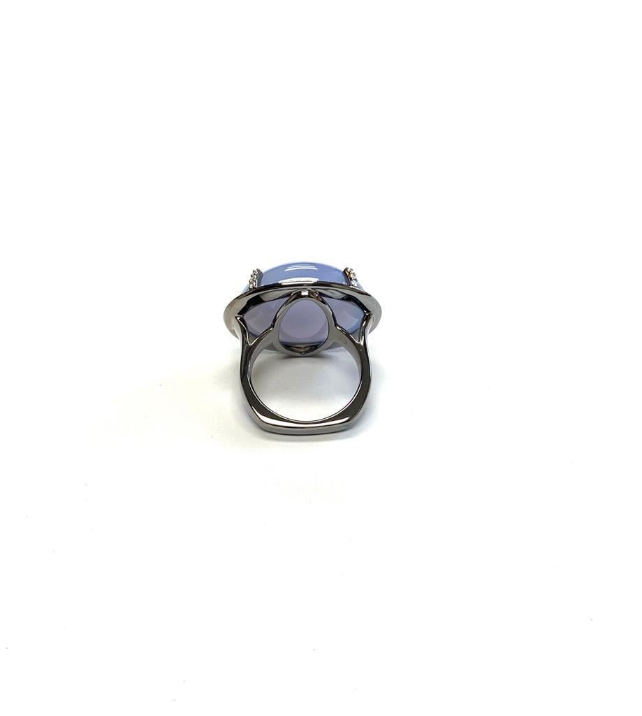Blue Chalcedony European Shank Ring with Diamonds in 18k White Gold and Black Rhodium, from 'Limited Edition' 

Stone Size- 21 x 17 mm

Gemstone Weight: Chalcedony- 7.99 Carats

Diamond: G-H / VS, Approx Wt: 0.40 Carats