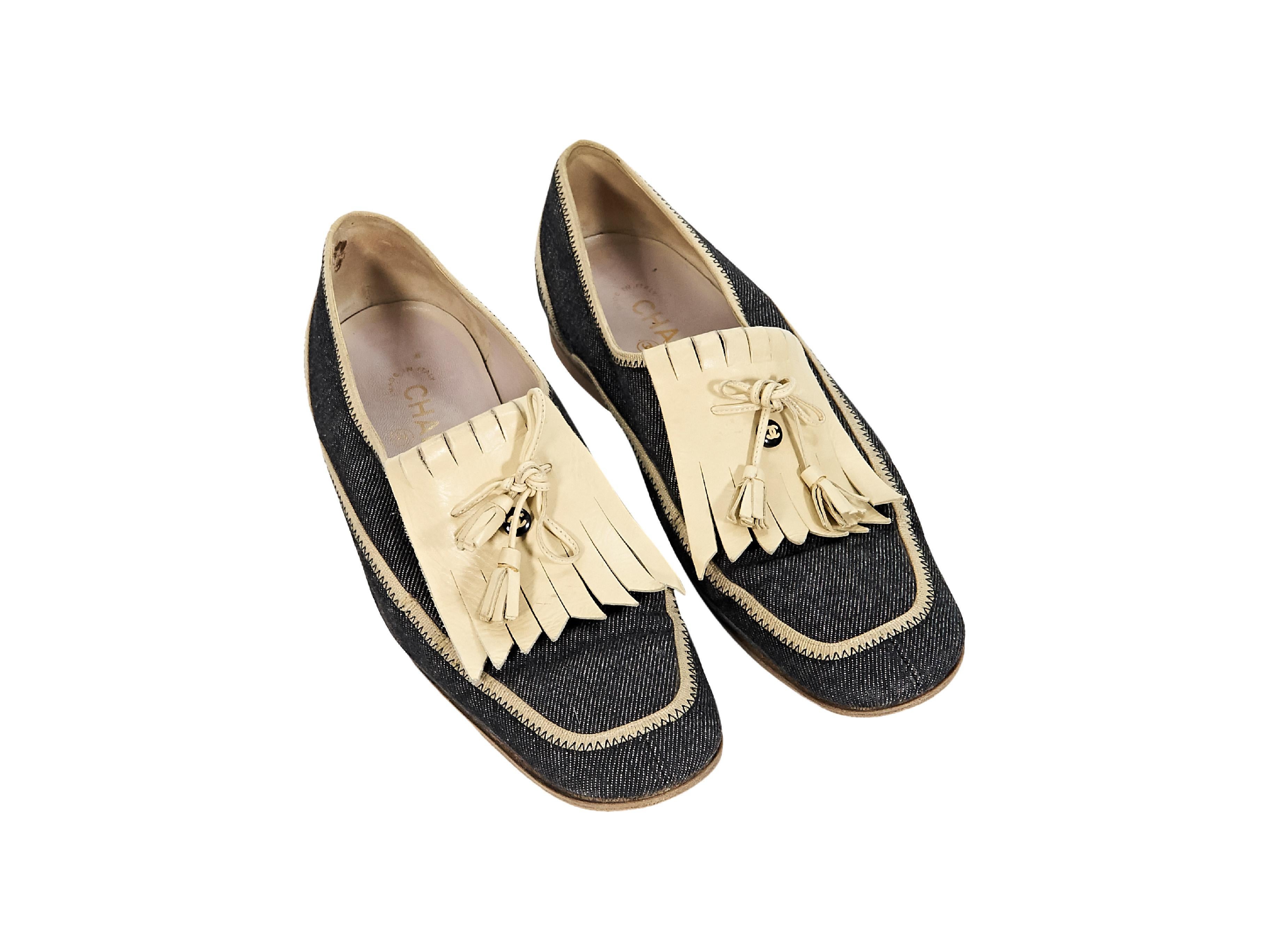 Product details:  Blue denim loafers by Chanel.  Ivory leather fringe tongue design.  Accented with tassels.  Low stacked heel.  Slip-on style.  0.75