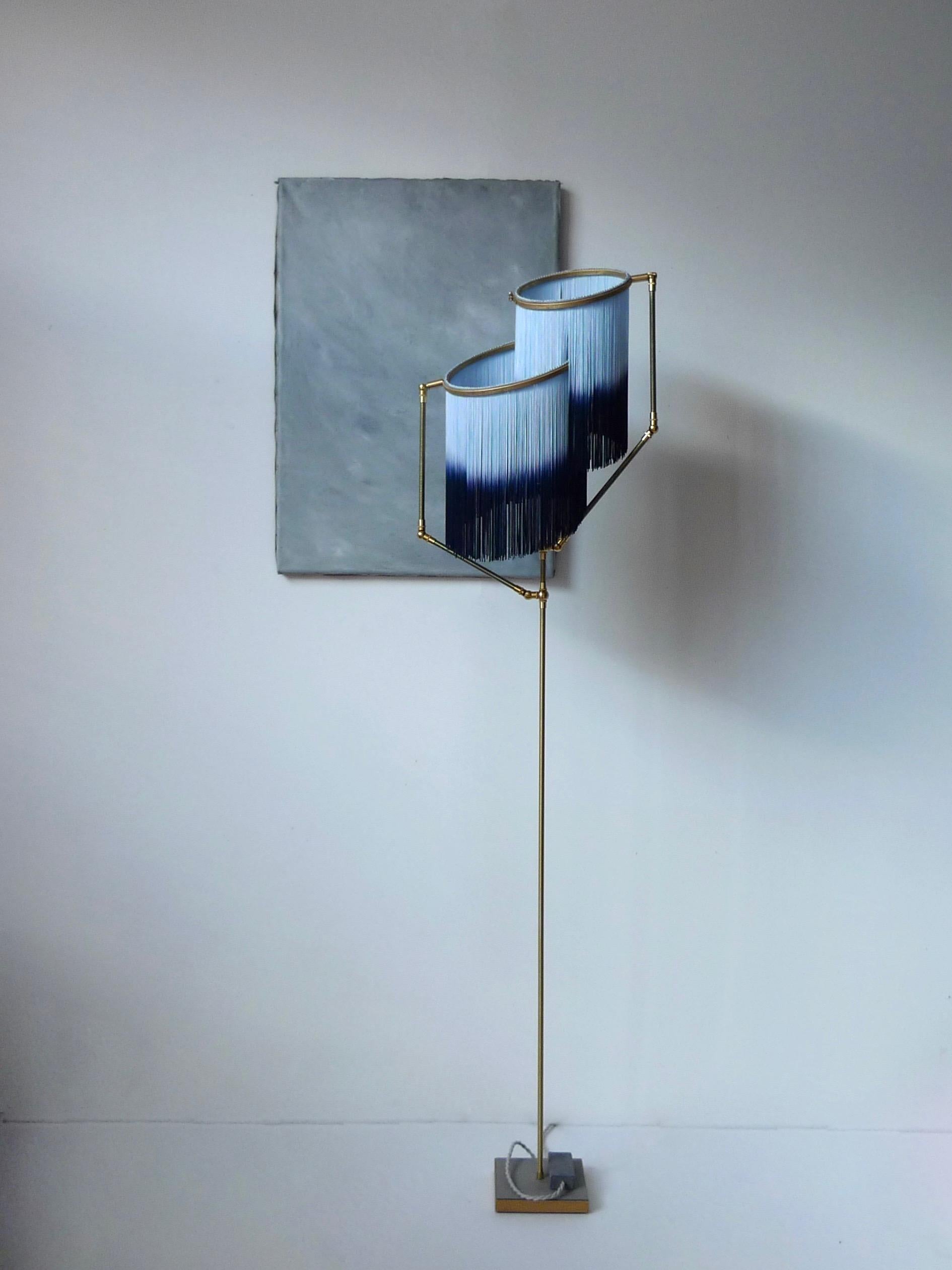 Blue charme floor lamp, Sander Bottinga

Dimensions: H 153 x W 38 x D 25 cm.
Hand-sculpted in brass, leather, wood and dip dyed colored fringes in viscose.
The movable arms makes it possible to move the circles with fringes in differed positions.
So