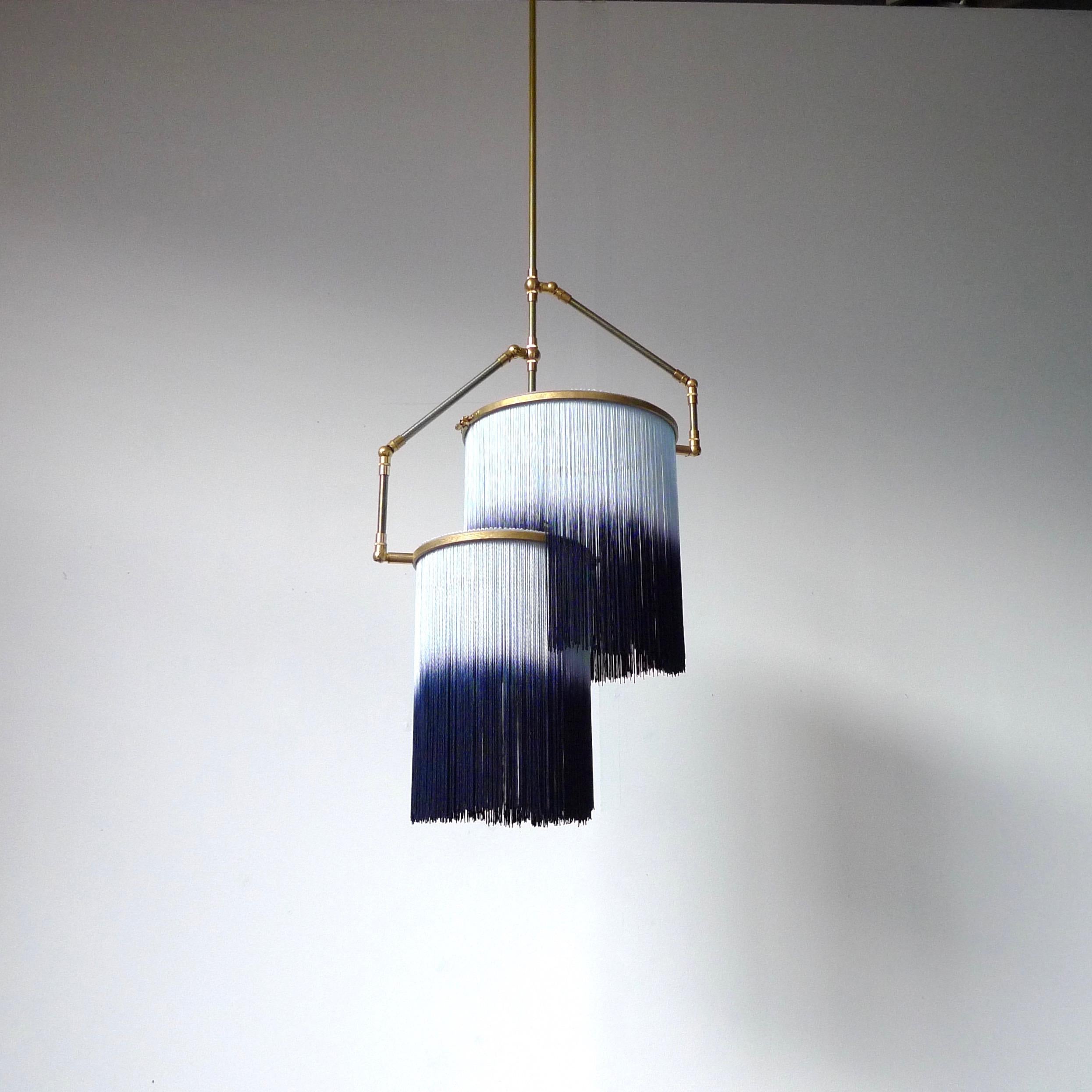 Blue Charme Pendant Lamp, Sander Bottinga

Dimensions: H 65 (can be customized) x W 38 x D 25 cm
Hand-Sculpted in brass, leather, wood and dip dyed colored Fringes in viscose.
The movable arms makes it possible to move the circles with fringes in