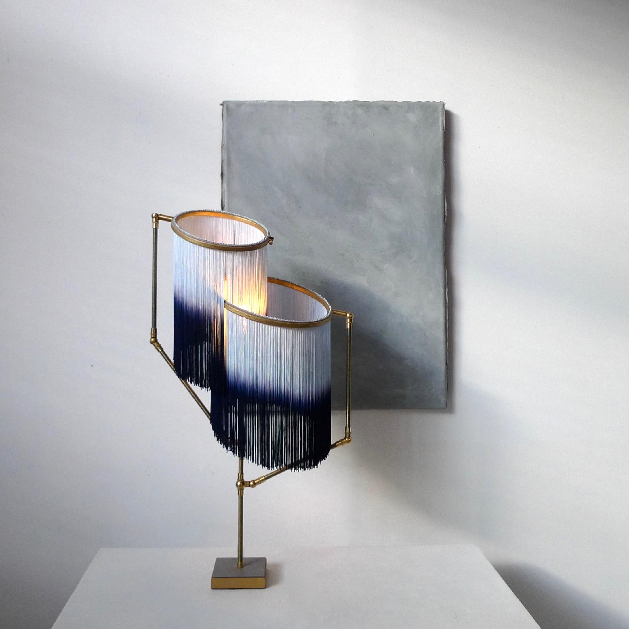 Blue Charme table lamp, Sander Bottinga

Dimensions: H 73 x W 38 x D 25 cm
Handmade in brass, leather, wood and dip dyed colored Fringes in viscose.
The movable arms makes it possible to move the circles with fringes in different positions.
So you