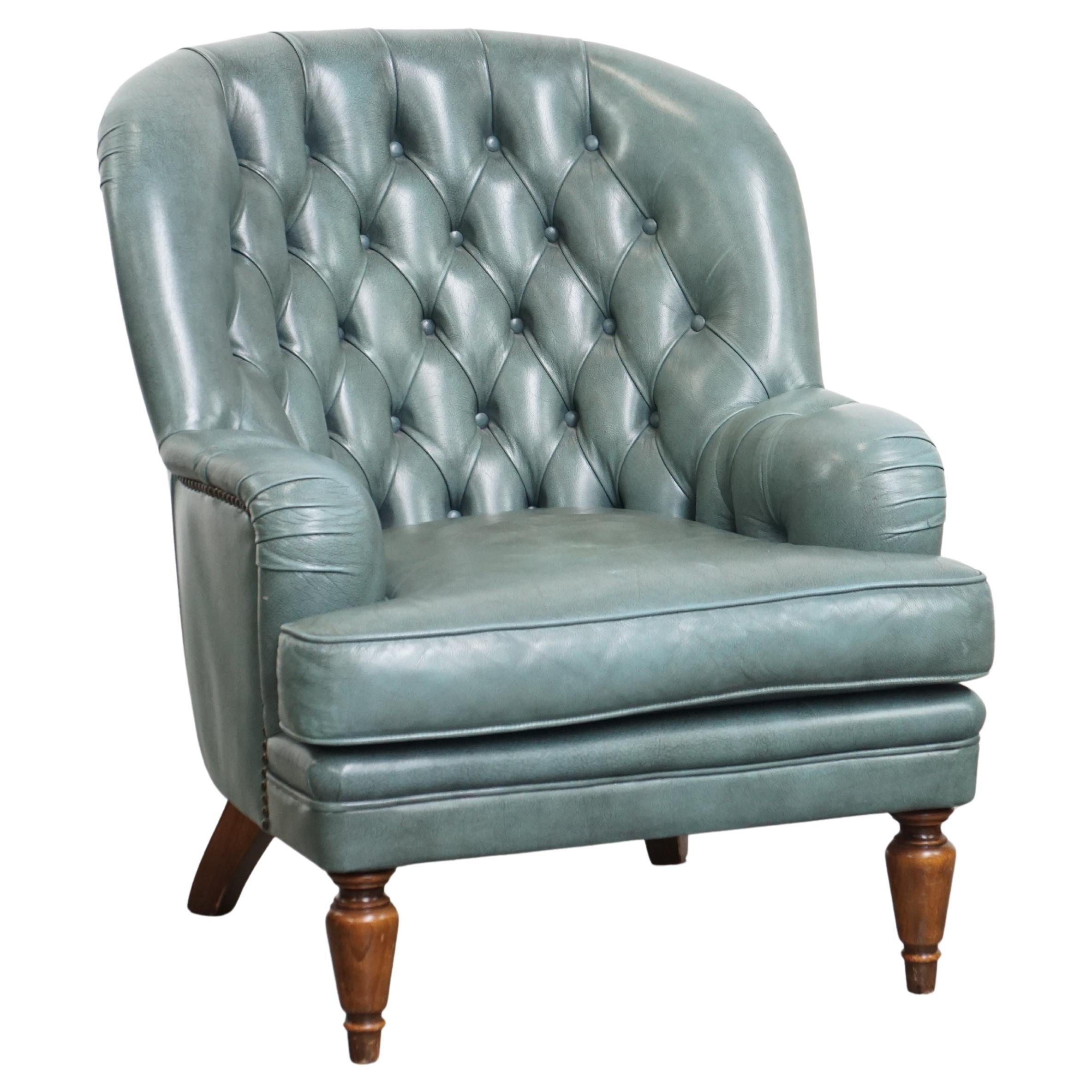 Fauteuil Chesterfield bleu en peau de vache de style anglais avec clous décoratifs.