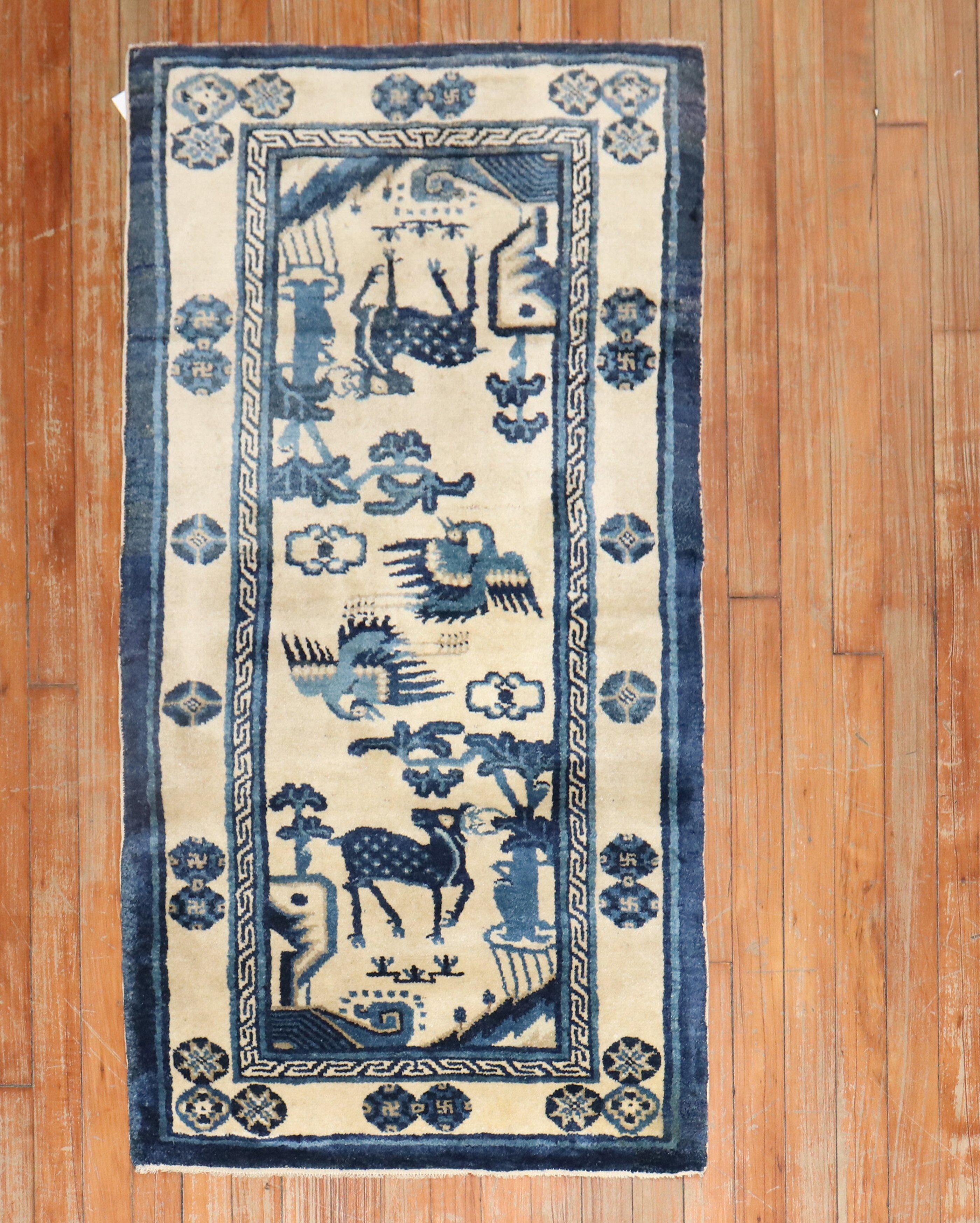 An early 20th-century Chinese Pictorial rug with an animal motif in light blue, navy and ivory

Measures: 2'3' x 4'5''.