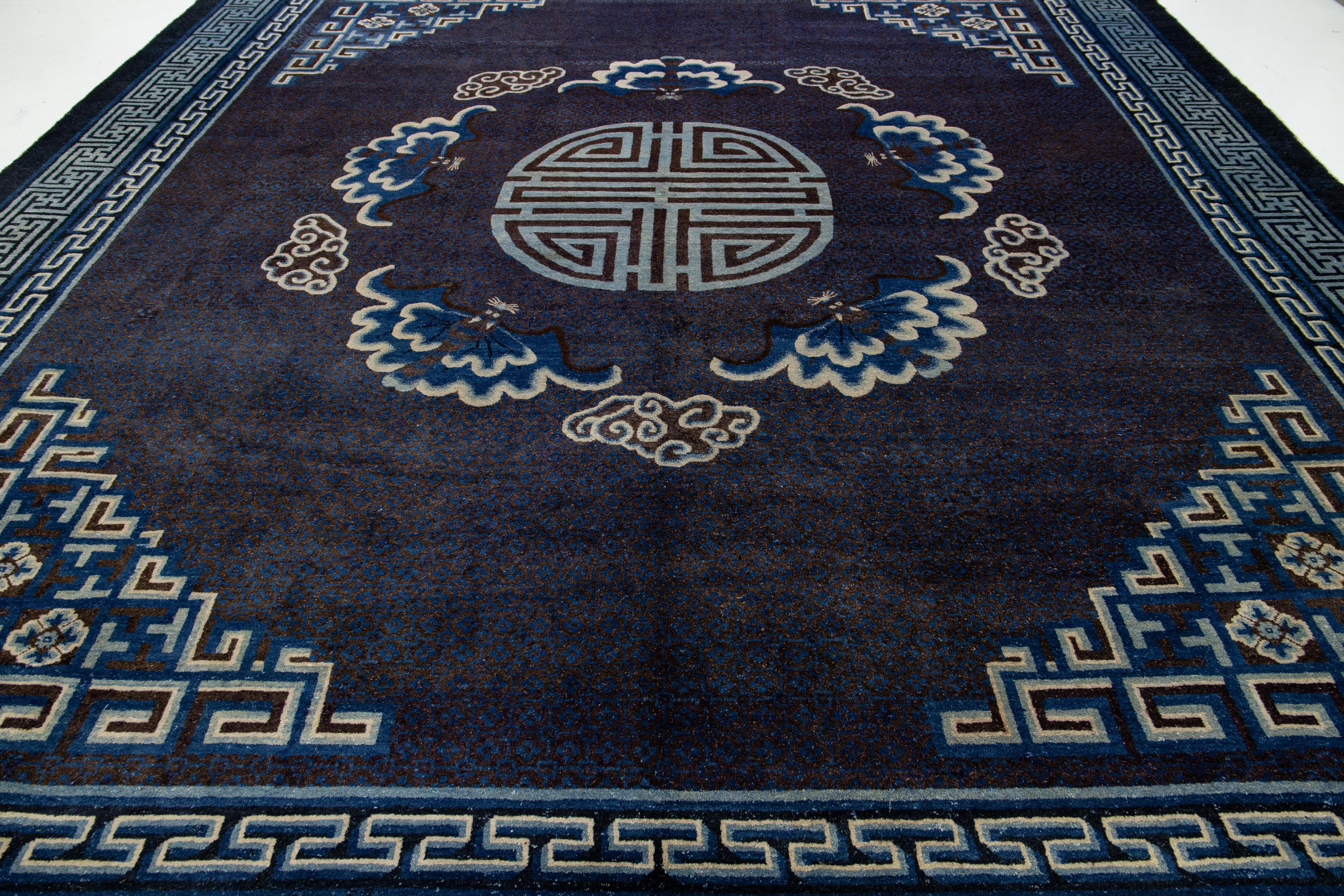 Behold this elegant antique Peking Chinese wool rug! Its navy blue field, decorative border, and beige accents showcase a stunning classic Chinese motif.

This rug measures 12'6'' x 14'2''.

 