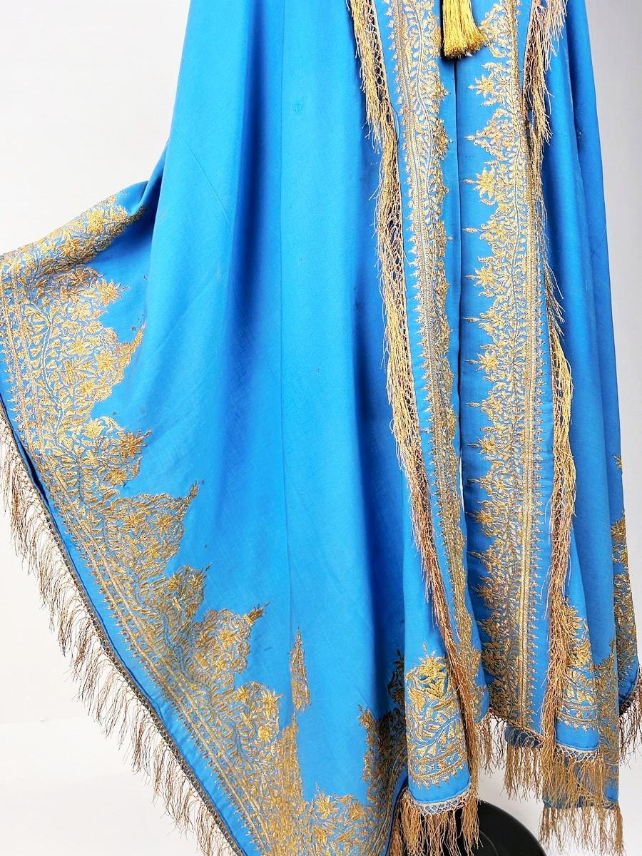 Last third of the 19th century
India for European fashion

Visite shawl in fine turquoise blue woolcloth, densely embroidered with gold Zari in India for the European market. Orientalist in spirit, this tour adorns the dresses à tournure or à