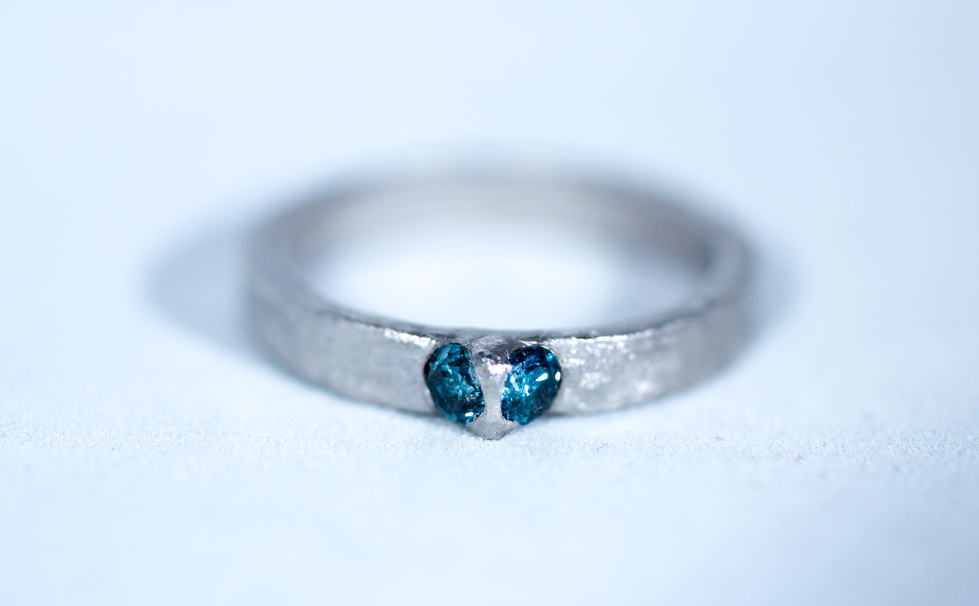 Blue diamonds in platinum, alternative engagement bridal band ring. A contemporary Simplicity Wide design in platinum with two flush-set blue diamonds. The streamlined shape and weightiness of platinum give this ring a certain stylish appeal. Wear