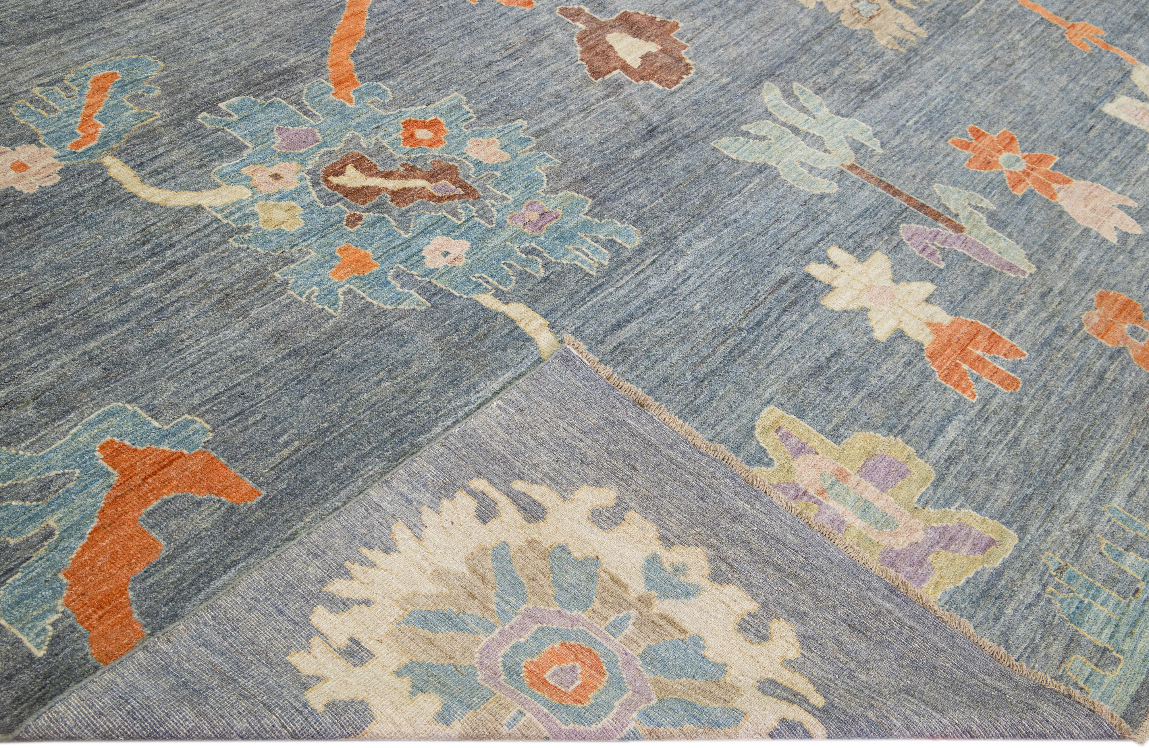 Beautiful modern Oushak hand-knotted wool rug with a blue field. This Turkish rug has multicolor accents in a gorgeous all-over classic floral pattern design.

This rug measures: 12' x 15'8