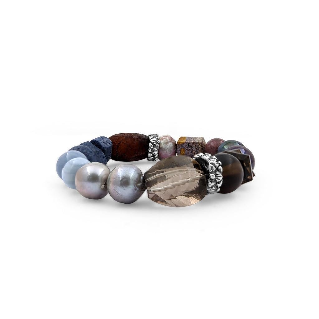 Elevate your accessory game with the captivating Blue Coral, Blue Opal, Pearl, Smoky Topaz, Ocean Jasper Stretch Bracelet in Sterling Silver by Stephen Dweck. This stunning piece features a harmonious blend of natural gemstones, including