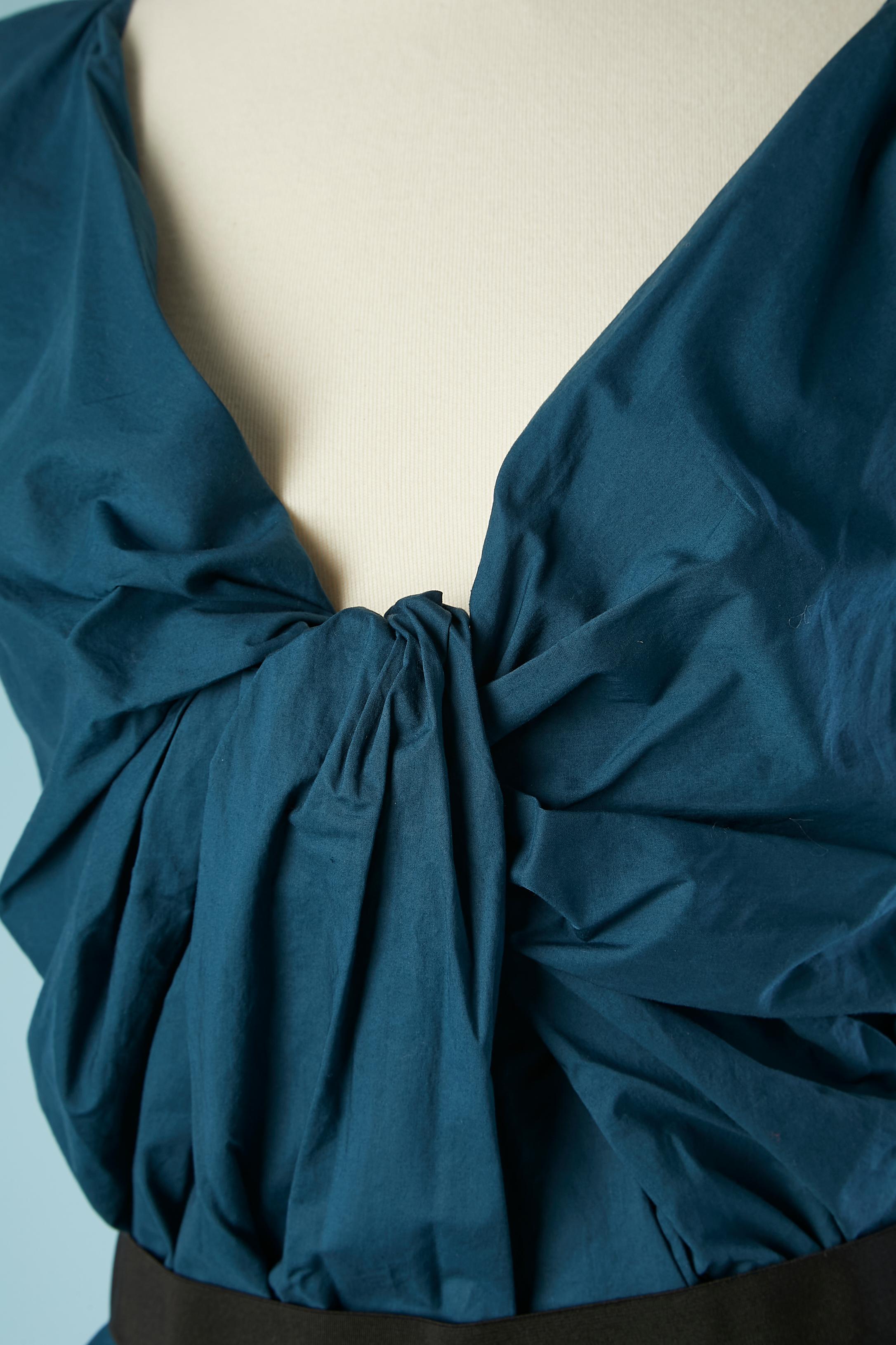 Blaues, ärmelloses Baumwollkleid mit gedrehter Drapierung im Vorderteil. Reißverschluss in der hinteren Mitte. Elastischer Gürtel in der Taille. Abgenähte Kante (Armausschnitt und Boden) Tasche auf beiden Seiten.
SIZE 38 (Fr) M 