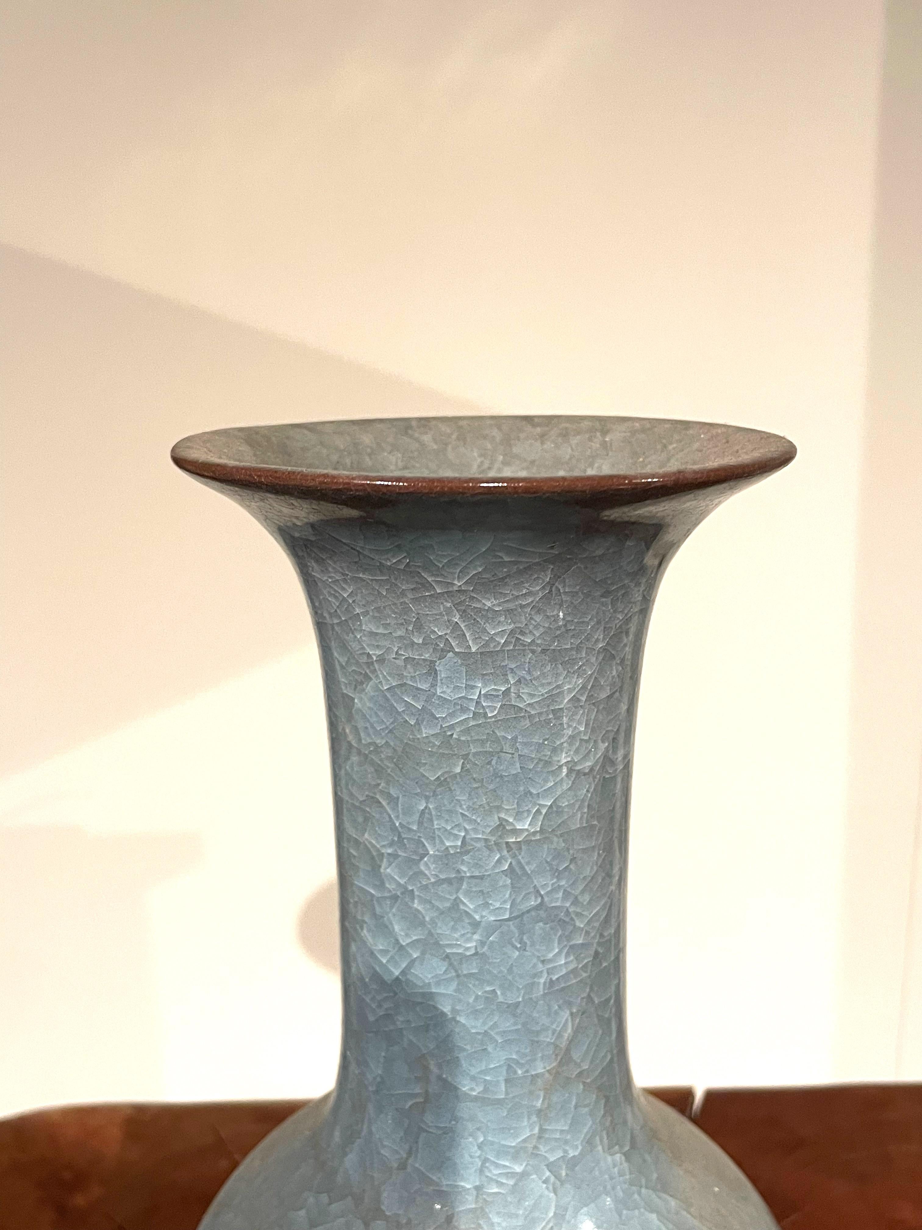Contemporary Chinese blue vase with crackle glaze.
Elongated tubular neck.
From a large collection with varying shapes and sizes.
ARRIVING APRIL