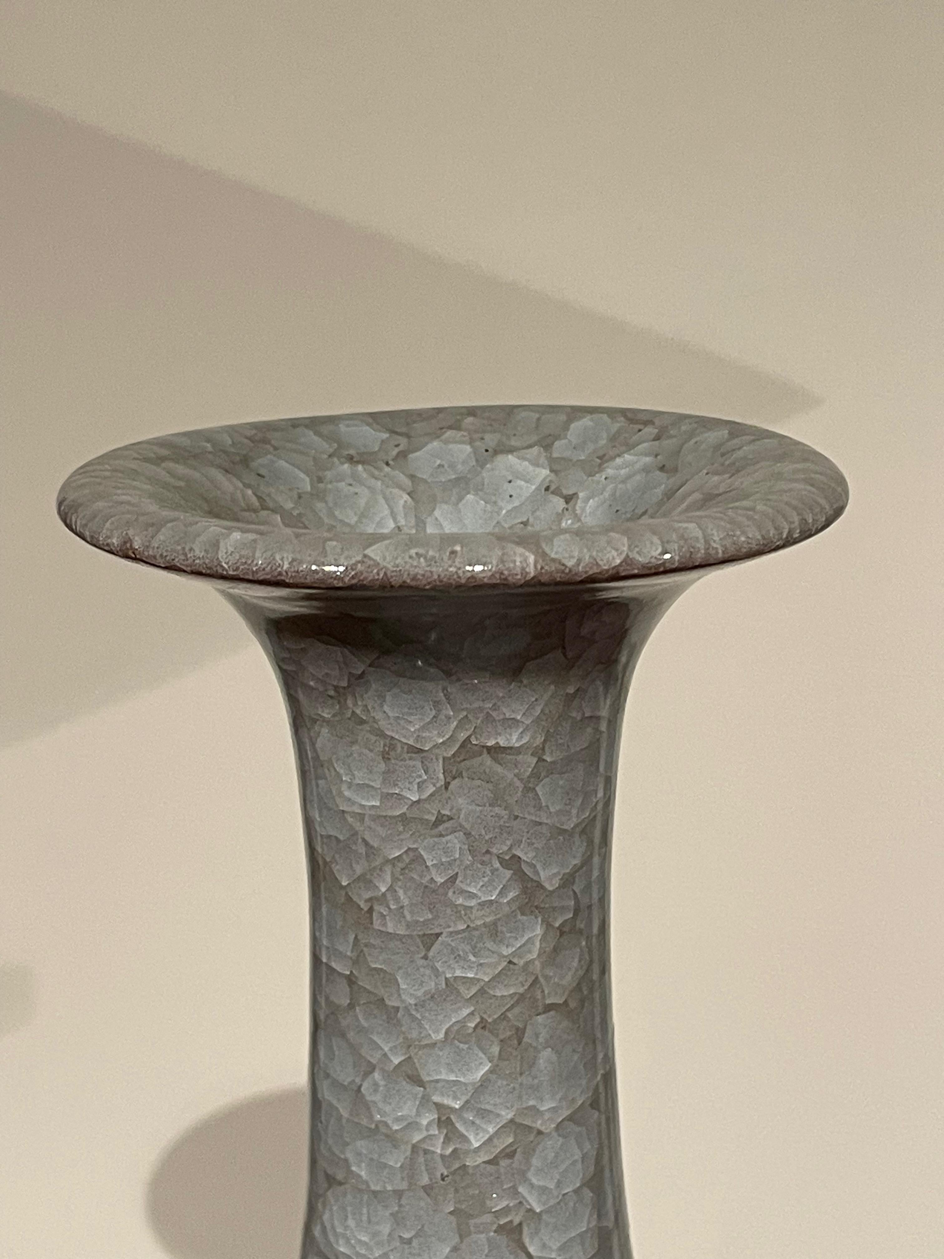Contemporary Chinese blue vase with crackle glaze.
Elongated tubular neck.
From a large collection with varying shapes and sizes.
