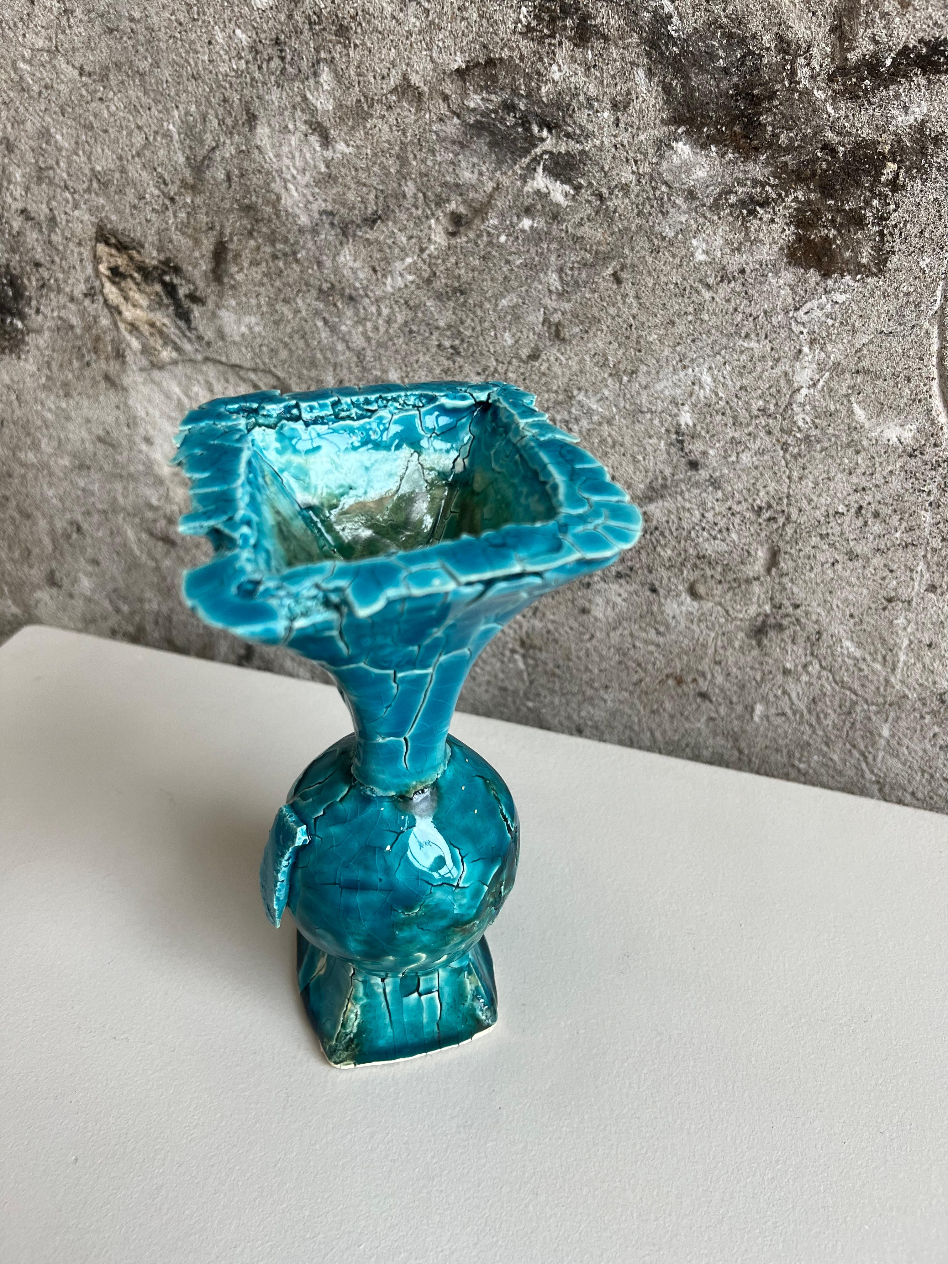 Uniquely textured crackle vase in a tapered urn style.  Colors of blue and teal are prominent throughout the vase with a green accent on the inside.  This piece was carefully handcrafted to achieve the interesting texture and composition of the