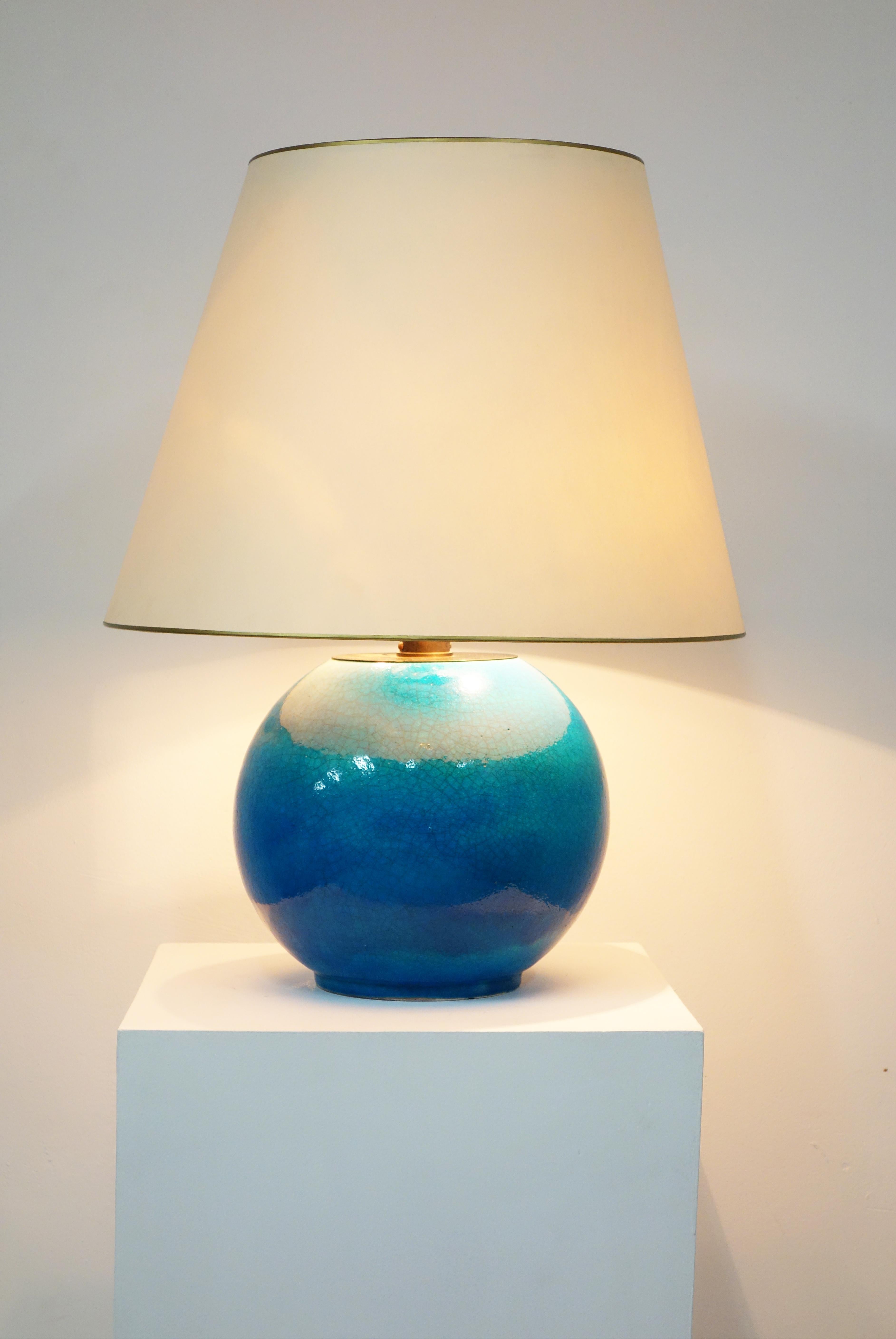 Blue crazed ceramic table lamp by Jean Besnard, circa 1930.
Important round lamp in blue crazed enameled ceramic. A glass white bowl supports the light shade.
The color is very beautiful: cloudy blue with shades.
Signed ‘JB FRANCE’ under the