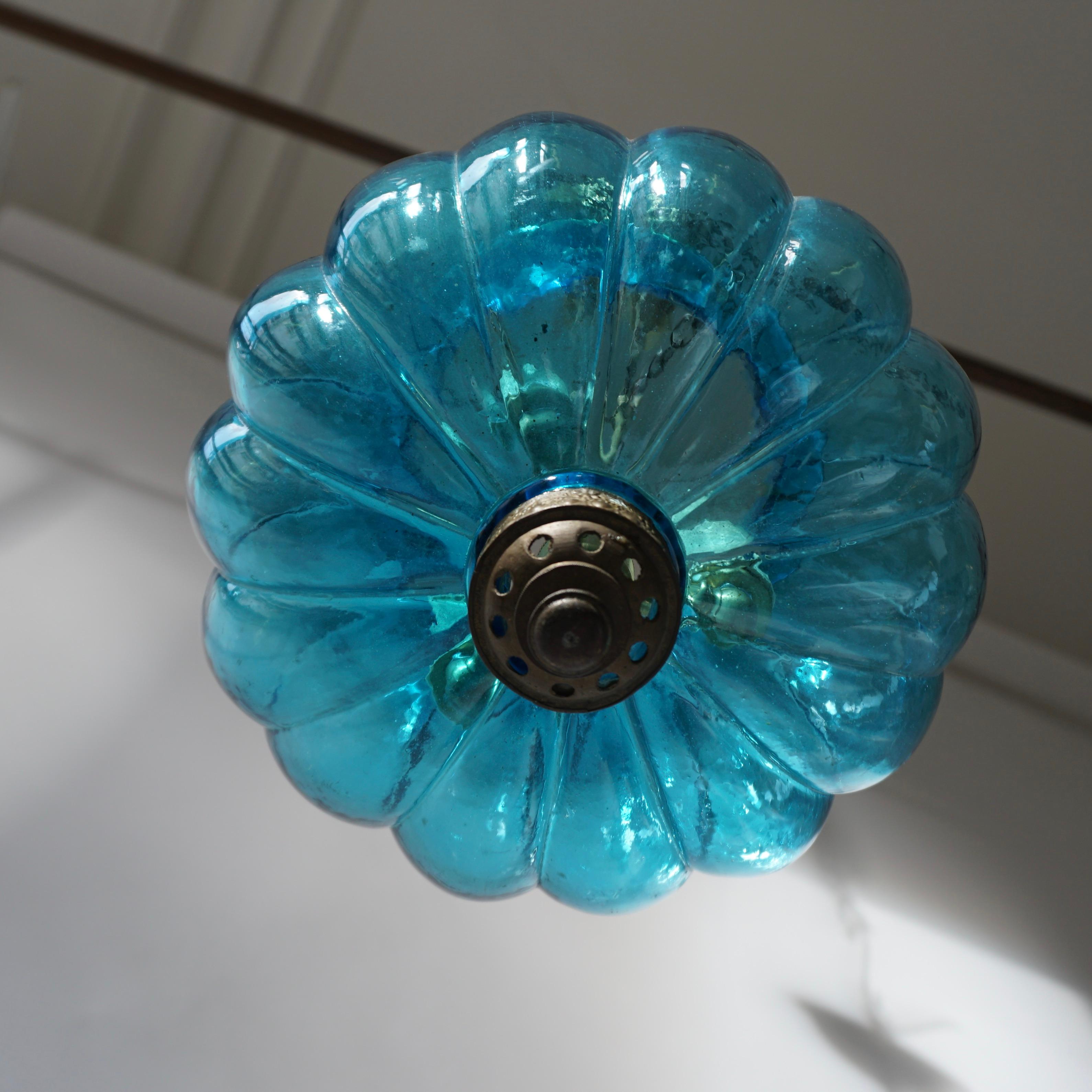 Anhänger in blauem Kristall, geschaffen von De Grelle Val St. Lambert im Jahr 1950 in Belgien.
Maße: Durchmesser 23 cm.
Gesamthöhe einschließlich Kette und Baldachin 100 cm.