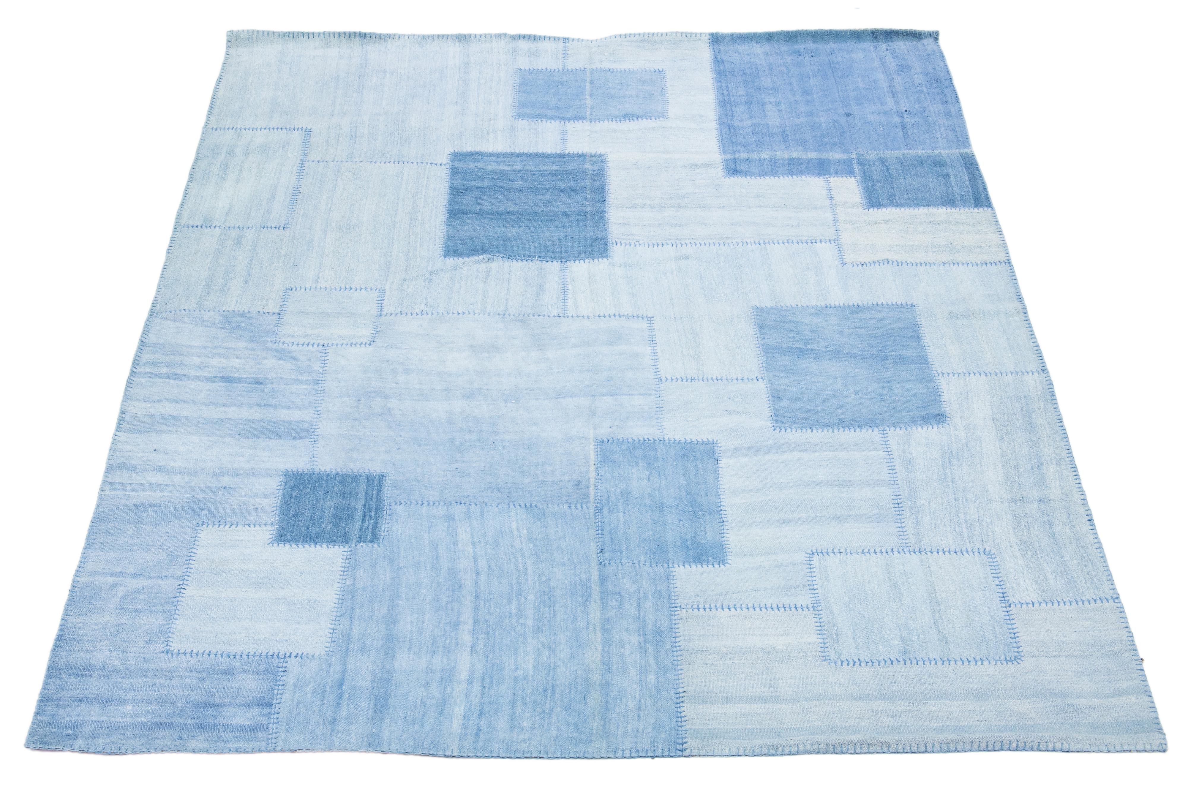 This rug showcases a modern Kilim flatweave design crafted from wool. It features a blue denim color base with a geometric abstract motif.

This rug measures 9'11