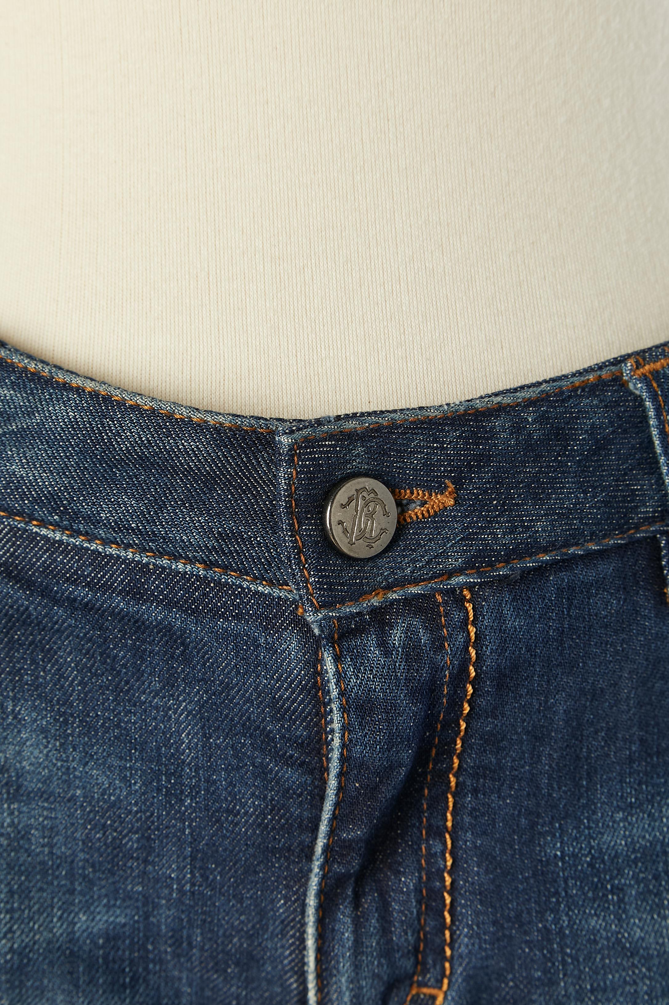 Blaue Denim-Jeans mit Metallic-Nieten und Öse an der Seite. Markenknöpfe und Markennieten neben den Taschen. Reißverschluss in der Mitte der Vorderseite. Echtheitshologramm. 
Zusammensetzung des Futters (von der Taille bis zu den Knien):