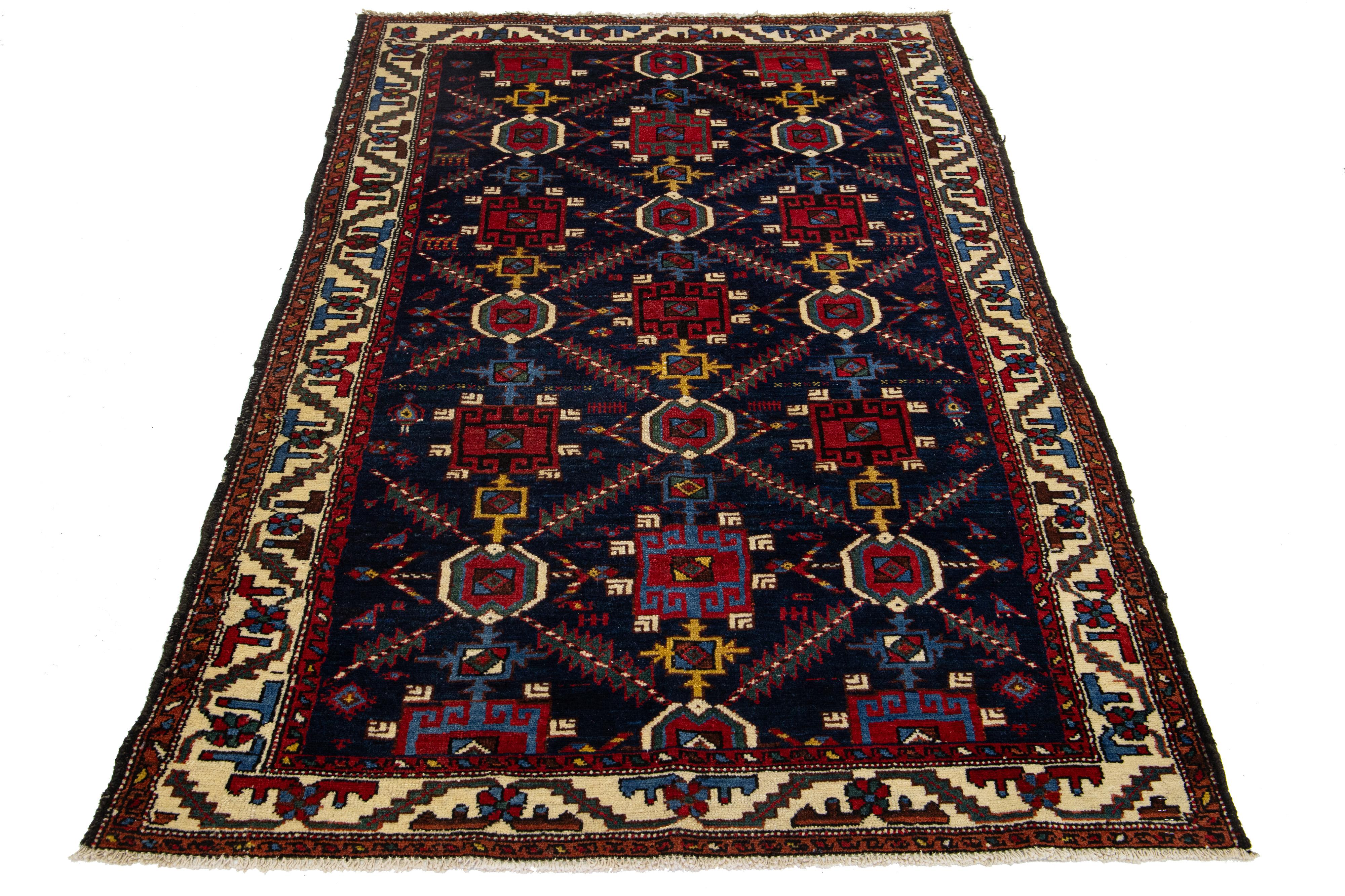 This elegant Antique Bakhtiari hand-knotted wool rug showcases a navy blue color field. It displays a timeless Persian design with yellow, beige, and red accents.

This rug measures 4'3