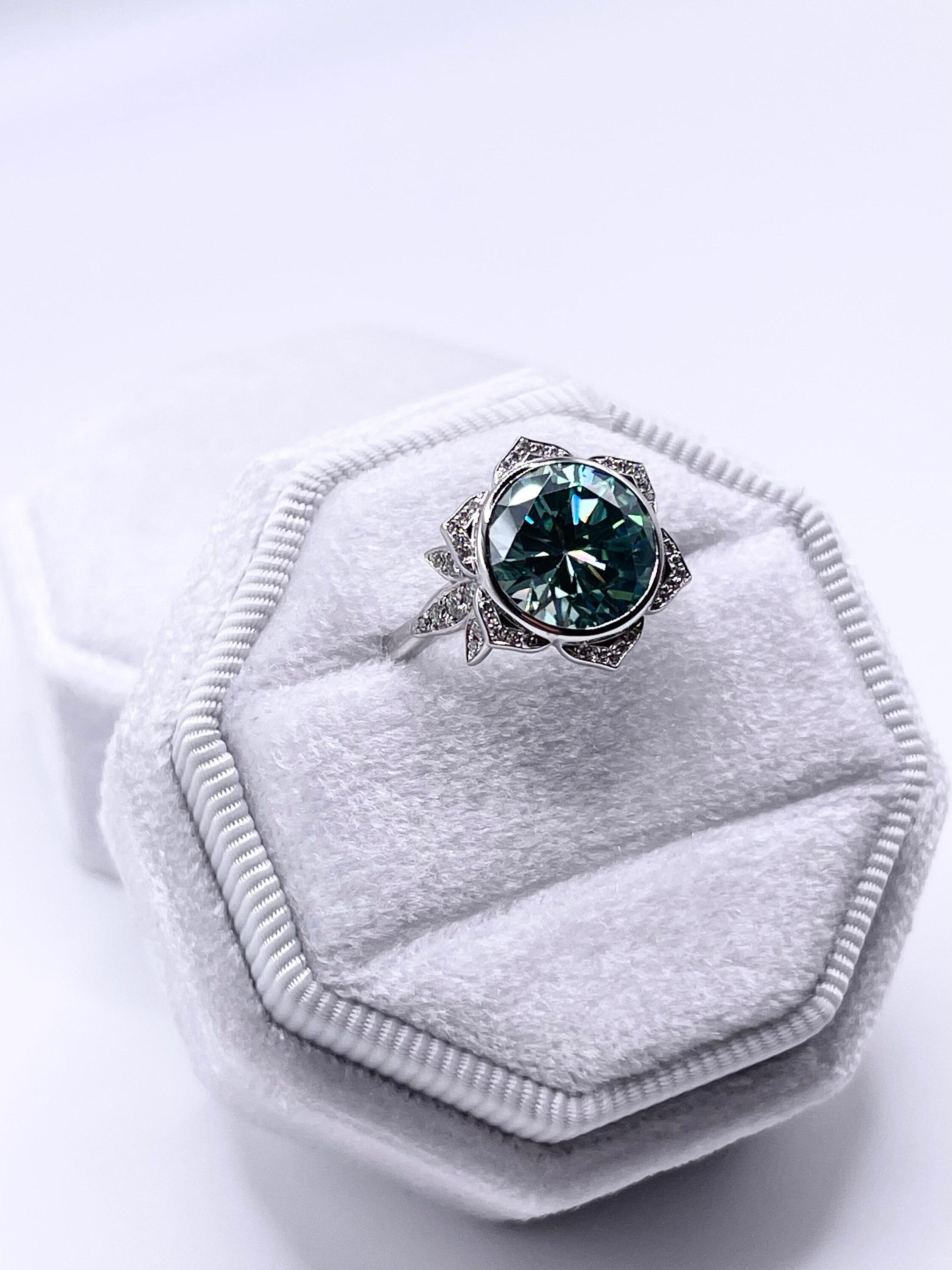 Cocktailring im Sonnenblumendesign aus 18 Kt. Weißgold mit einem großen 10-mm-Moissanit in der Mitte und feinen Diamanten von Reinheit VS und Farbe F an den Seiten. Der Ring hat die Größe 5,5 und kann auf jede Größe angepasst werden.

*Das Produkt