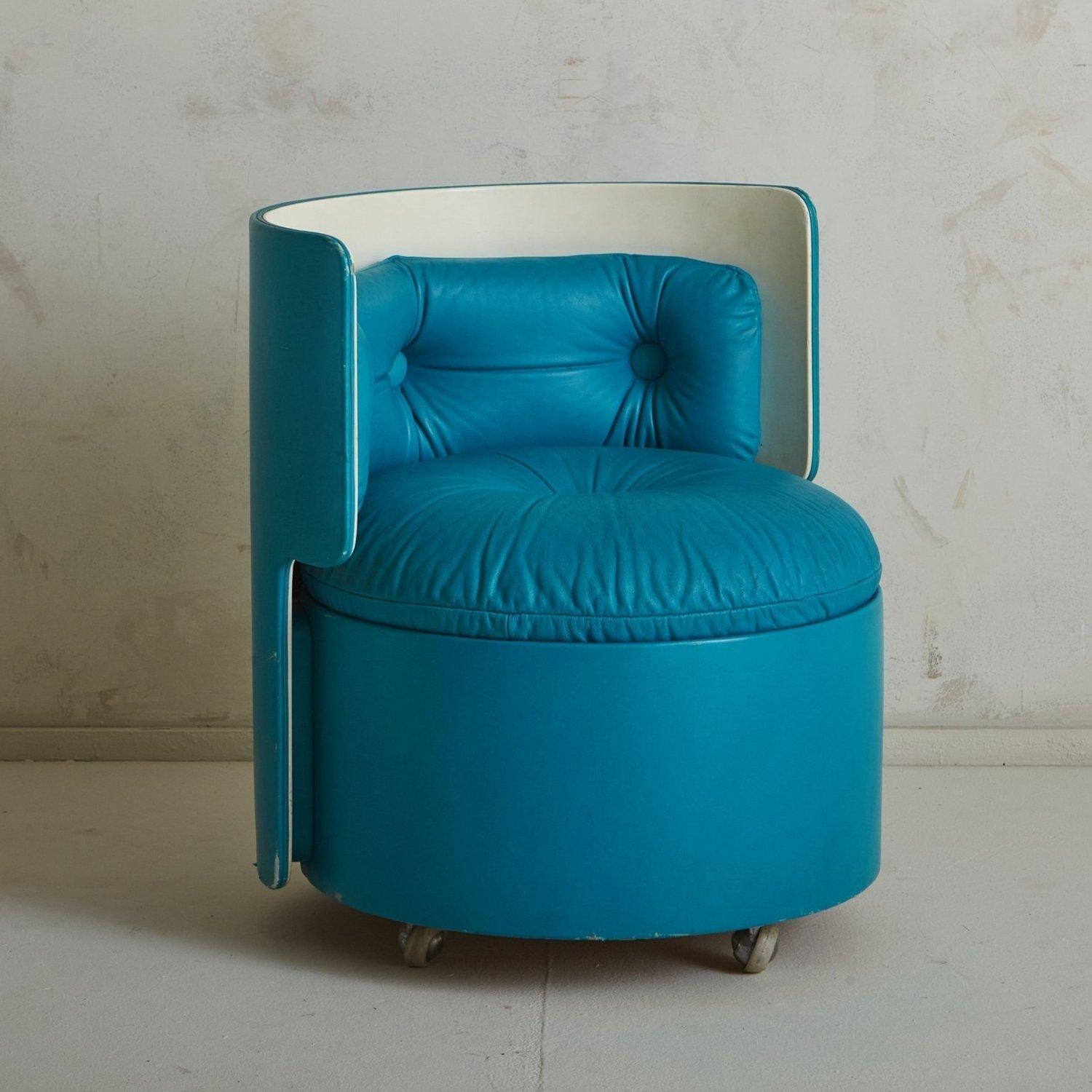 An Italian ‘Dilly Dally’ chair designed by Luigi Massoni for Poltrona Frau in 1968. This chair is part of a modular vanity set, in which the chair nests into the table creating a cylinder. It has a barrel frame clad in teal leather with a cream