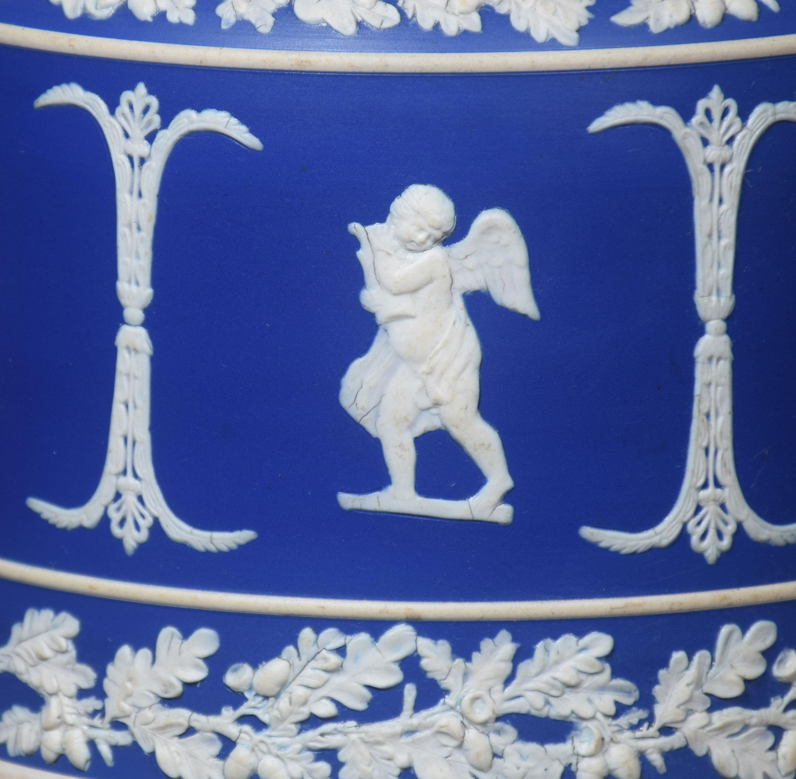 A late 19th century blue dip Jasperware cylindrical form cheese dish and cover, with acorn finial, decorated in relief with winged figures within bands of oak leaves.
Dimensions:
Height 10 inches
Width 11 inches
Depth 11 inches.
