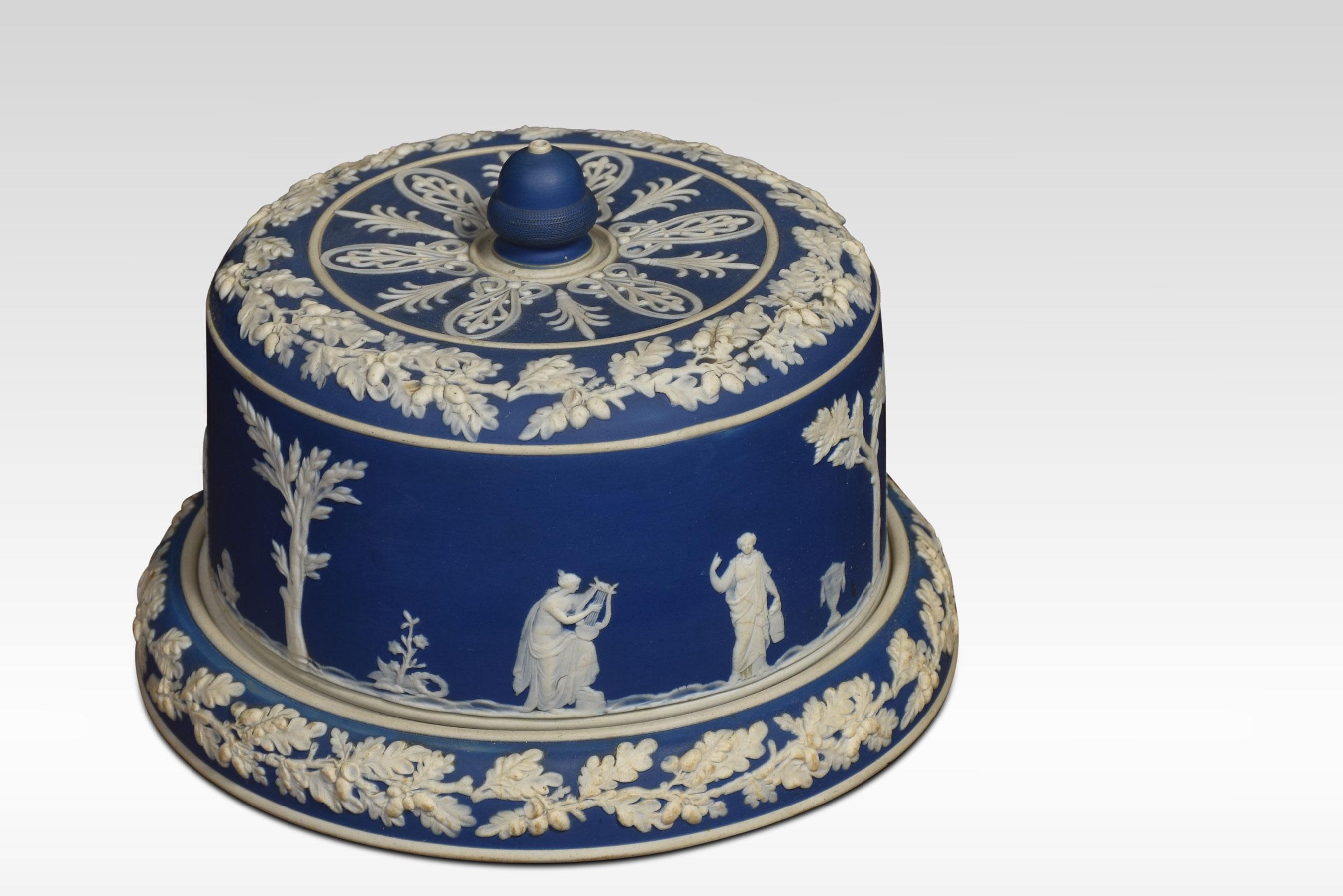 A late 19th-century blue dip Jasperware cylindrical form cheese dish and cover, with acorn finial, decorated in relief with winged figures within bands of oak leaves.
Dimensions
Height 8 inches
Width 10.5 inches
Depth 10.5 inches.
