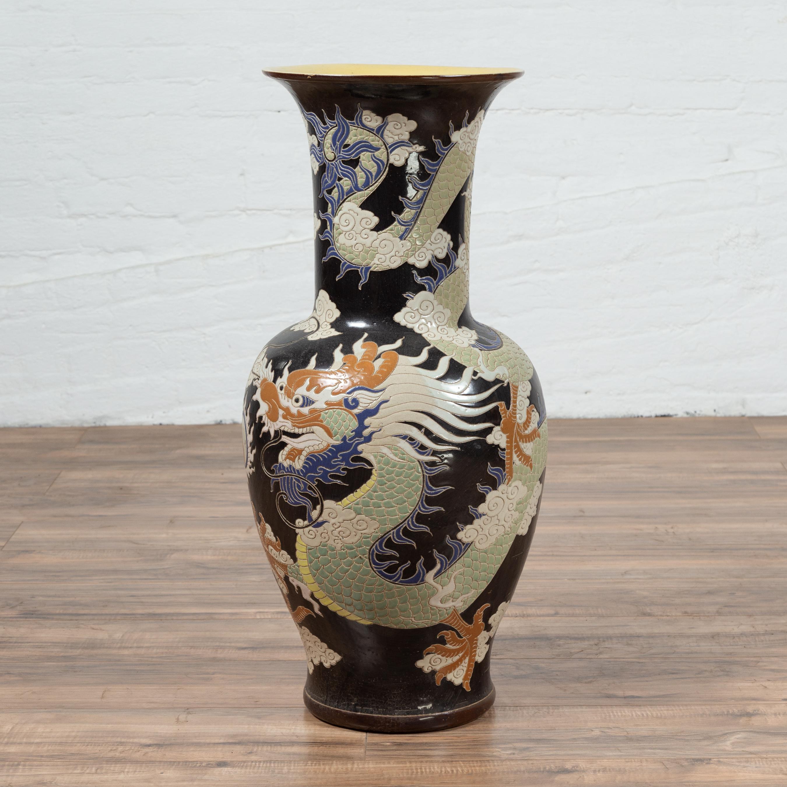 A Vietnamese blue dragon motif contemporary altar vase found in a temple. Charming our eyes with its black ground highlighting the beauty of its blue dragon motif, this large altar vase was found in a Vietnamese temple. Its flaring neck, along with