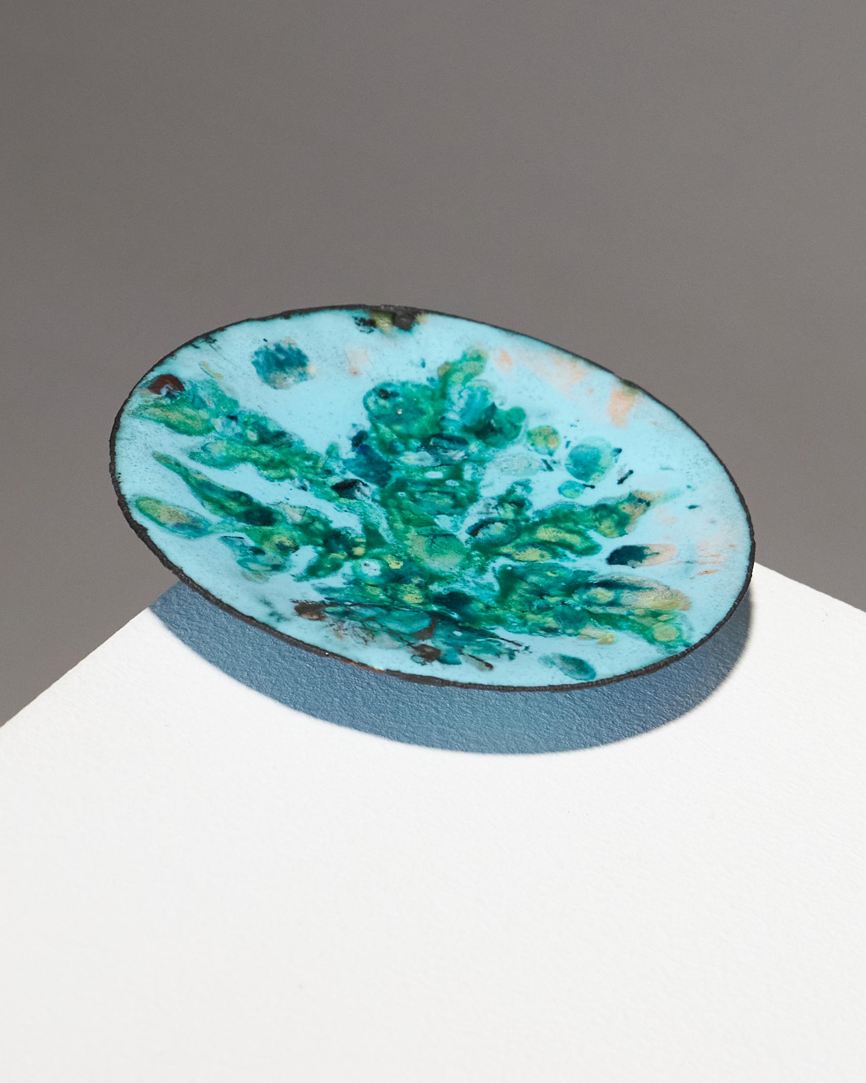 Petit plat en émail réalisé par l'artiste Geneviève Martineau Dausset dans les années 1950. Recouverte d'un riche émail bleu, cette pièce présente de légers signes d'âge, qui ne font qu'ajouter à son charme authentique. En très bon état, il reste un