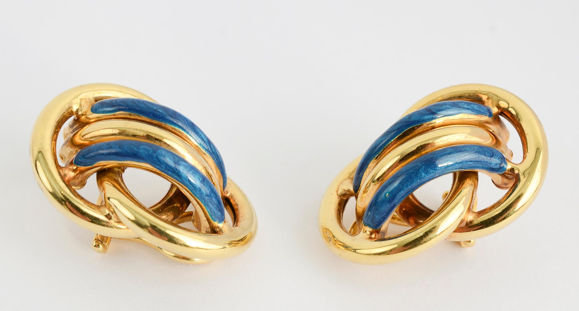 Chic and sporty gold earrings with enamel in a beautiful shade of blue.
The earrings consist of two overlapping gold circles over which are three bands of half hoops. The earrings are 1 1/16 inches in length.
Clip backs can be converted to