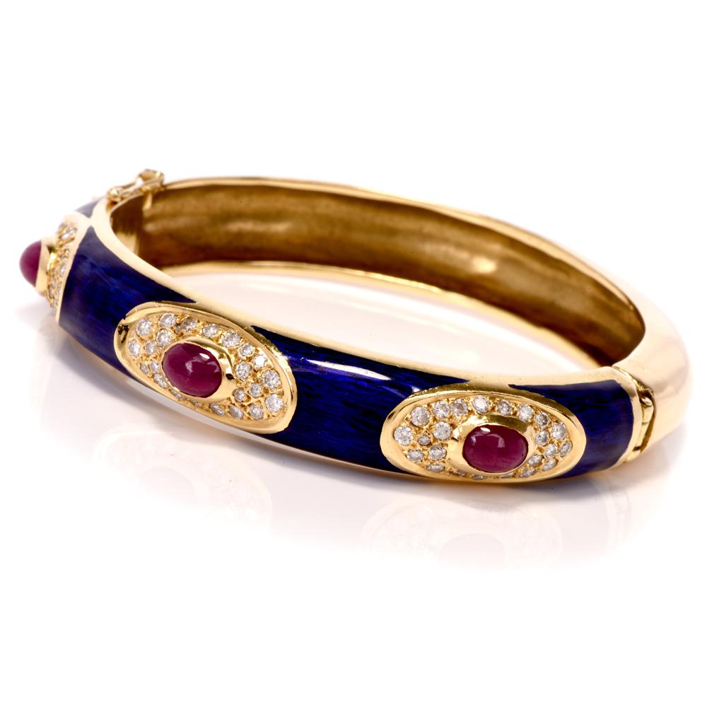 This ruby, diamond, and Italian blue enamel bangle bracelet is crafted in solid 18k yellow gold. Weighing 53.4 grams and measuring 7”. This bangle bracelet features 3 bezel set rubies approx. 2.15 carats surrounded by approx. 72 round-cut diamonds