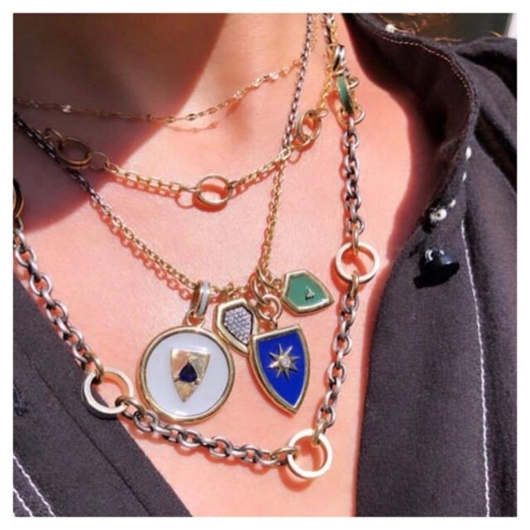 An updated take on the classic shield shape.  This pendant, in stunning royal blue enamel, is set off by a gold star with a center diamond.  It has chunky jump rings, and hangs off of a 14 Karat gold chain, finished with our star logo