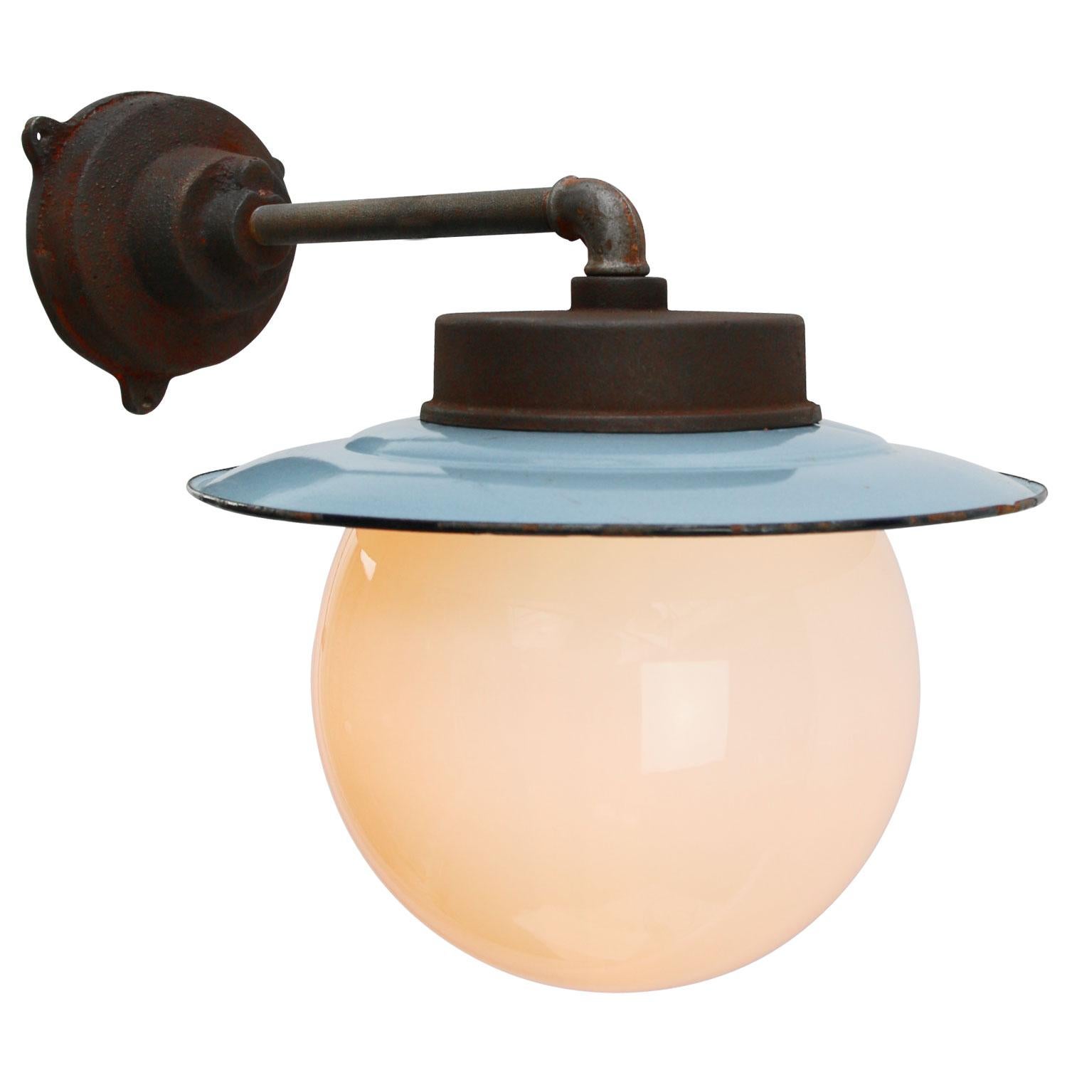 Blue enamel industrial wall light.
Opaline glass. Measures: 

Diameter cast iron wall piece: 12 cm. Three holes to secure.

Weight: 6.5 kg / 14.3 lb

All lamps have been made suitable by international standards for incandescent light bulbs,