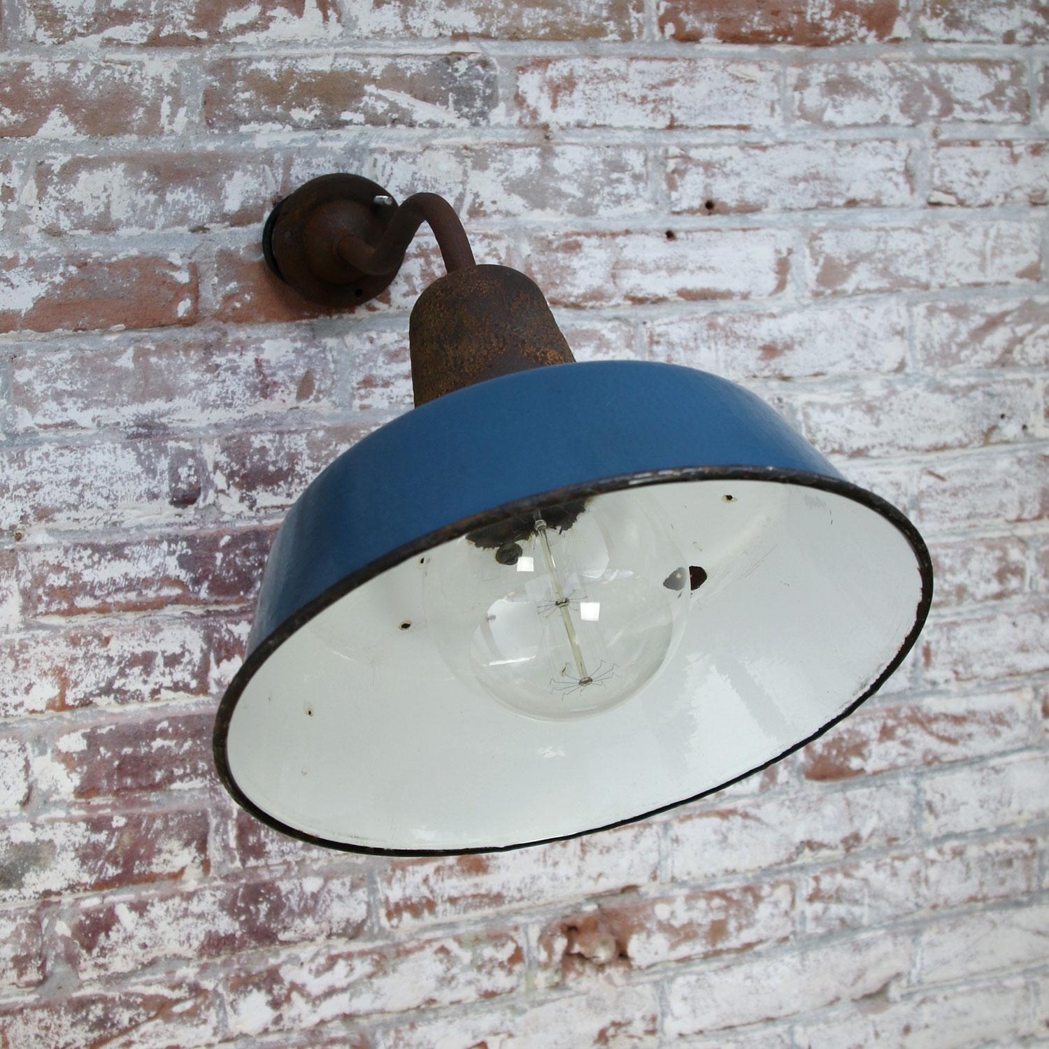 Blue enamel industrial wall light. White enamel interior, cast iron top and arm and wall piece.
Diameter cast iron wall mount: 9 cm, three holes to secure.

Weight: 6.7 kg / 14.8 lb

Priced per individual item. All lamps have been made suitable