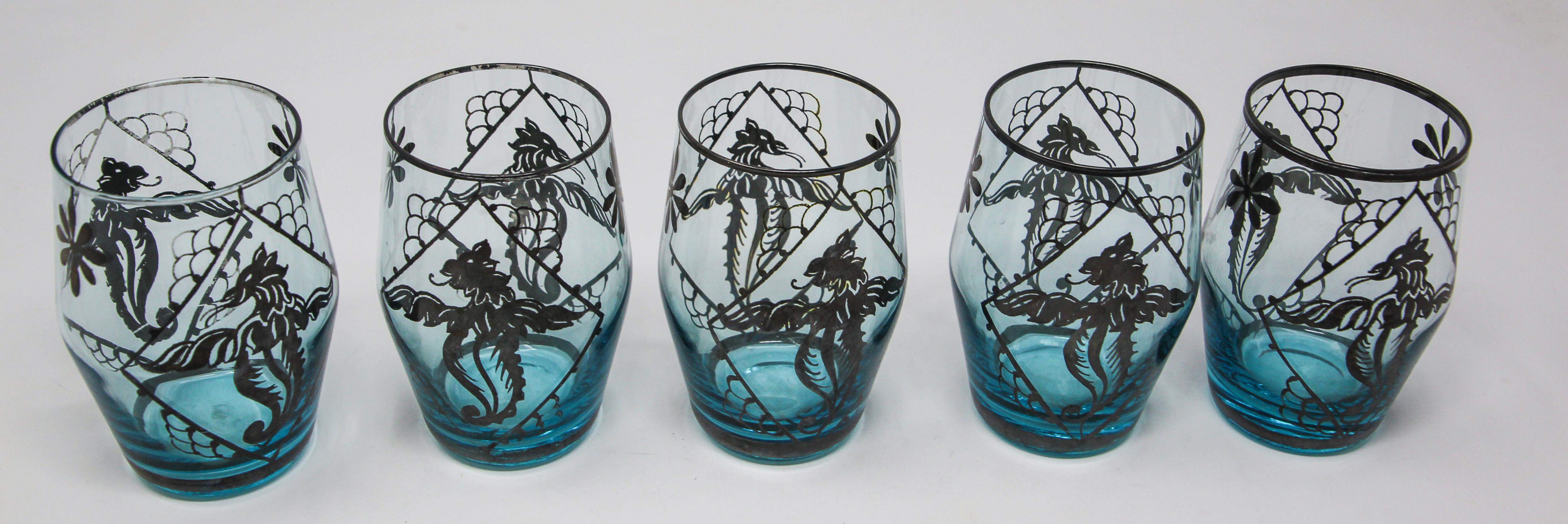 Blue enamelled Bohemian glass liquor set or aperitif service of five glasses.
Five beautiful Bohemia blown glass blue glasses.
Mouth blown glass in a stunning light blue color enhanced with hand painted silver enamel with flying dragons like