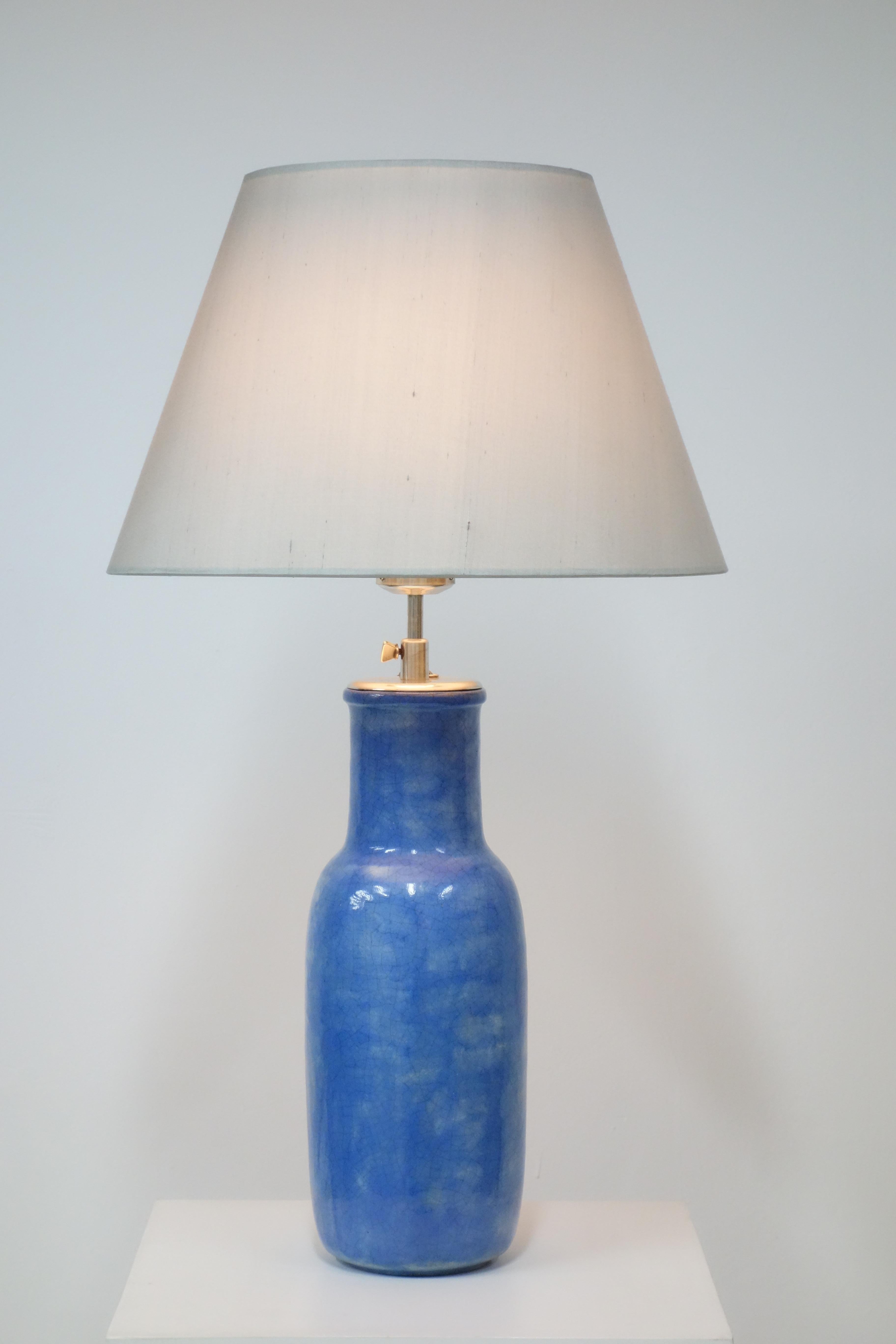 Blue enameled ceramic table lamp by André Groult, circa 1920. 
Important lamp in enameled ceramic. The shouldered base is entirely covered with crackled cloud blue enamel.
Monogramm with the flower basket under the base.

Dimensions with the