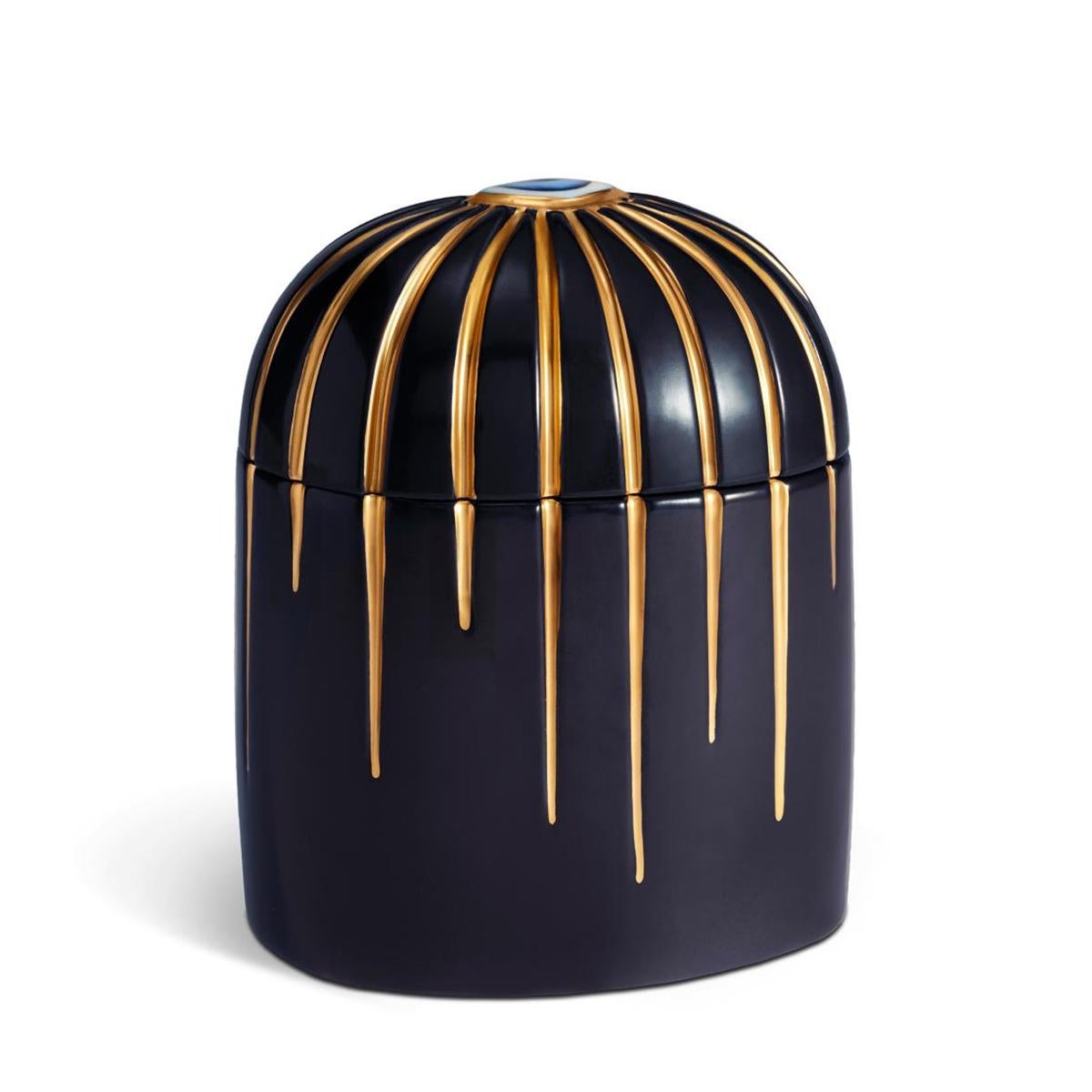 Caja para velas Ojo Azul de porcelana con
un ojo azul porcelana en el párpado. En azul oscuro 
porcelana con acabado chapado en oro de 24 quilates. 
Incluye cera de parafina con mecha simple, fragancia 
vetiver verde. Se entrega en una lujosa caja