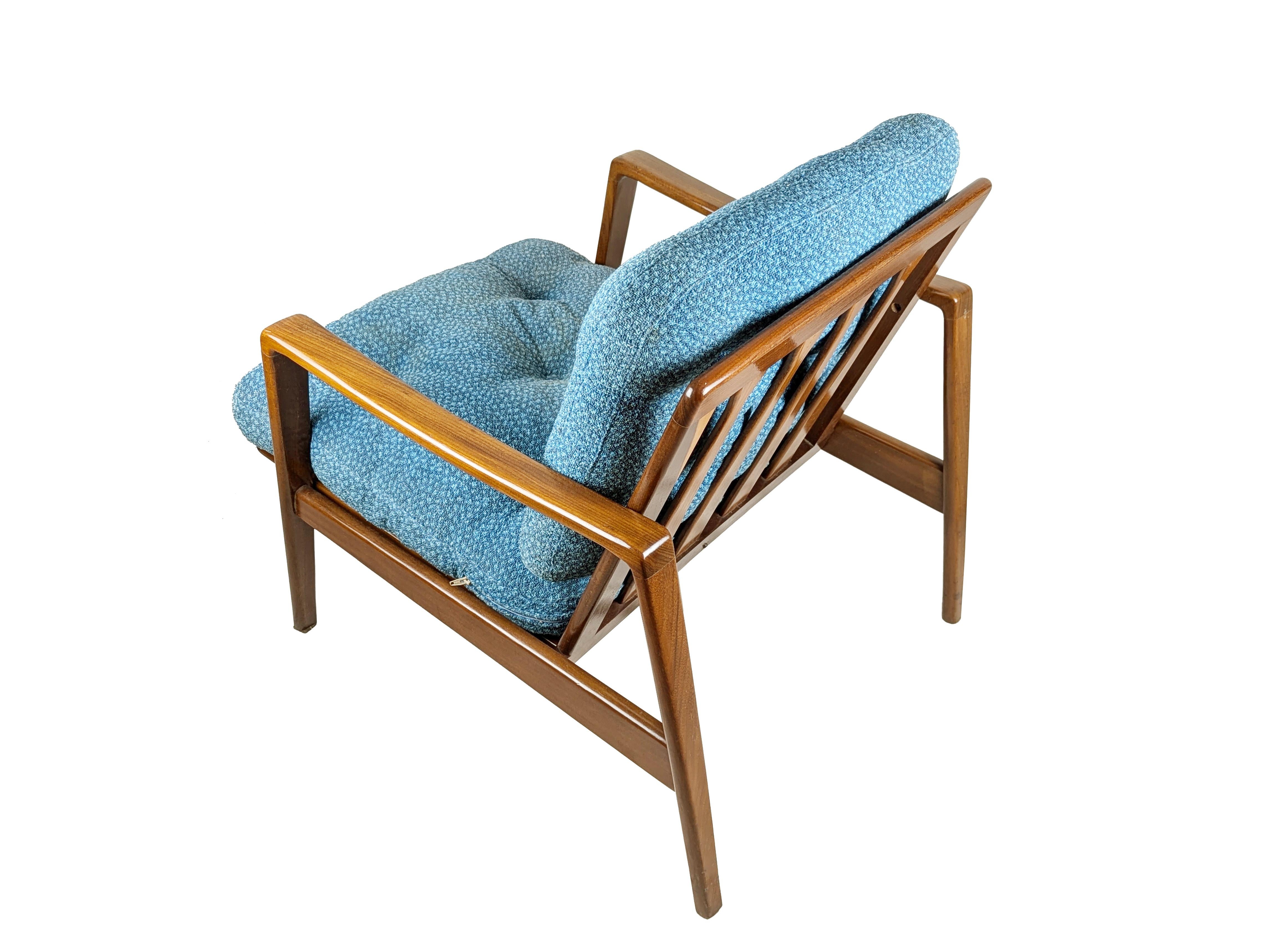 Removable armchair with teakwood structure and cushioned seat and backrest upholstered with light blue fabric (defects). Thin metal bands covered in plastic material to support the seat.
The structure is composed of 5 wooden elements joined together