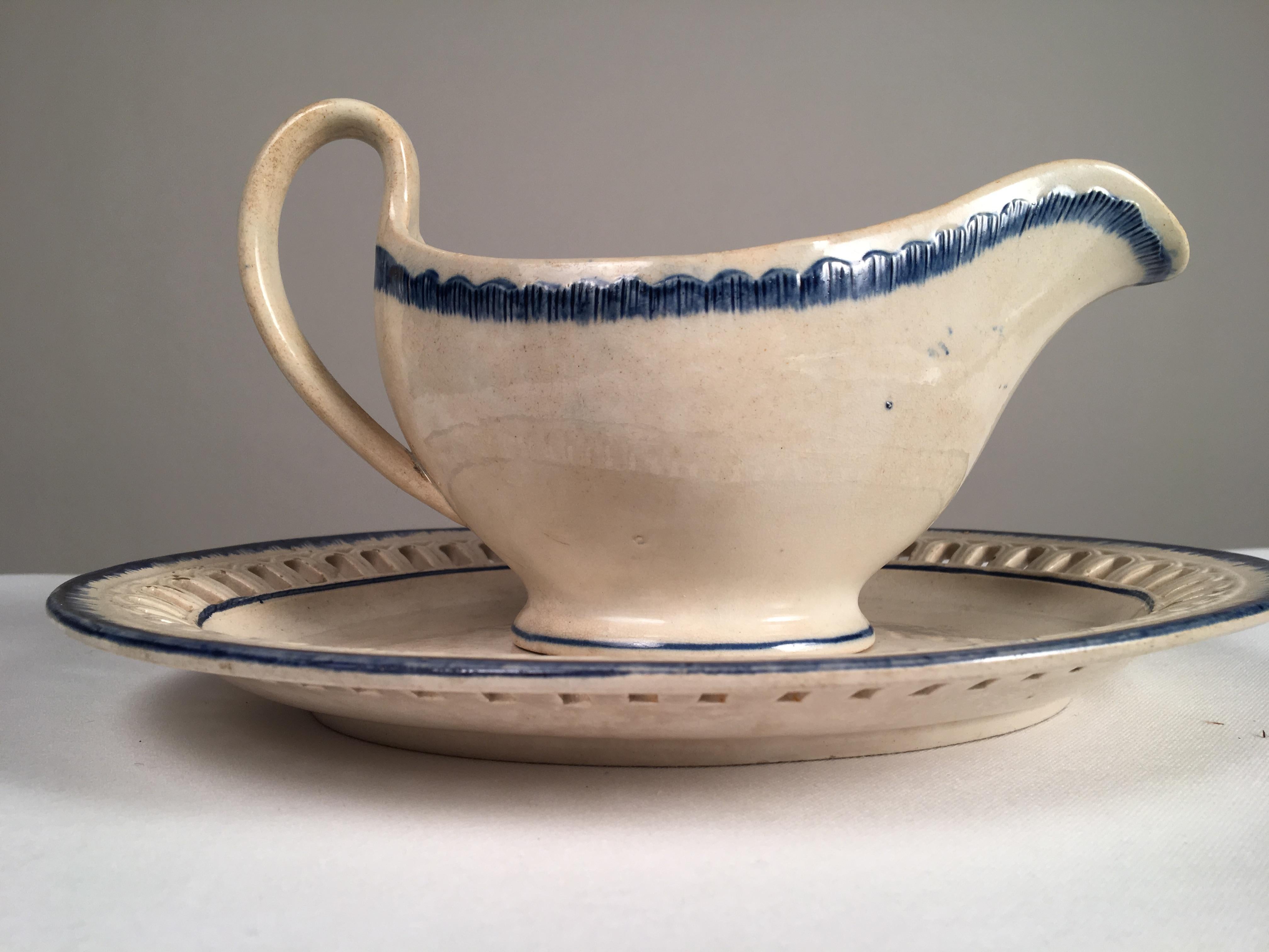 A blue and white feather-ware serving platter along with a feather-ware gravy boat with oval reticulated tray, probably Leeds, circa 1840.