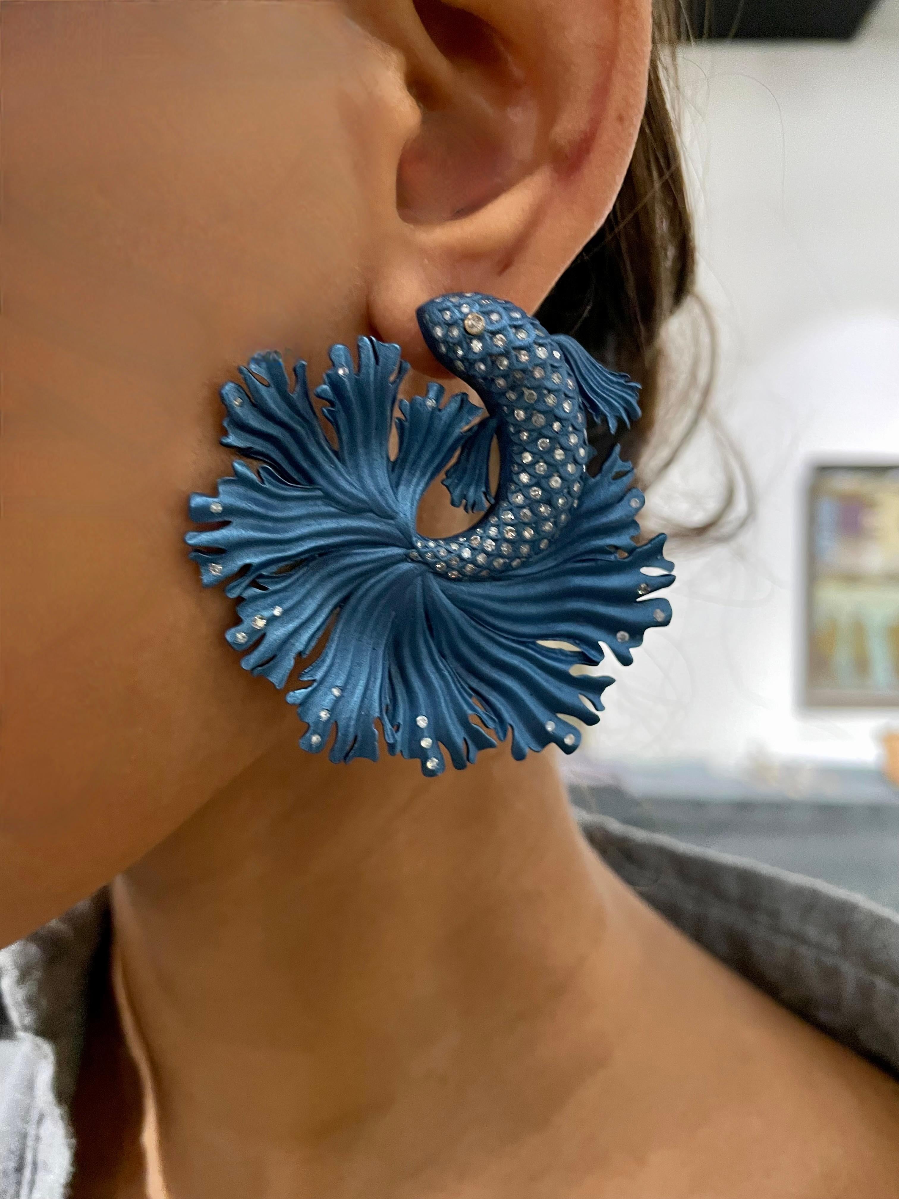 Make a statement with these stunning Blue Fish Earrings, handcrafted from eco-friendly recycled aluminum and 18kt gold. Adorned with 2.41 carats of sparkling diamonds, these earrings are the perfect blend of luxury and environmental consciousness.