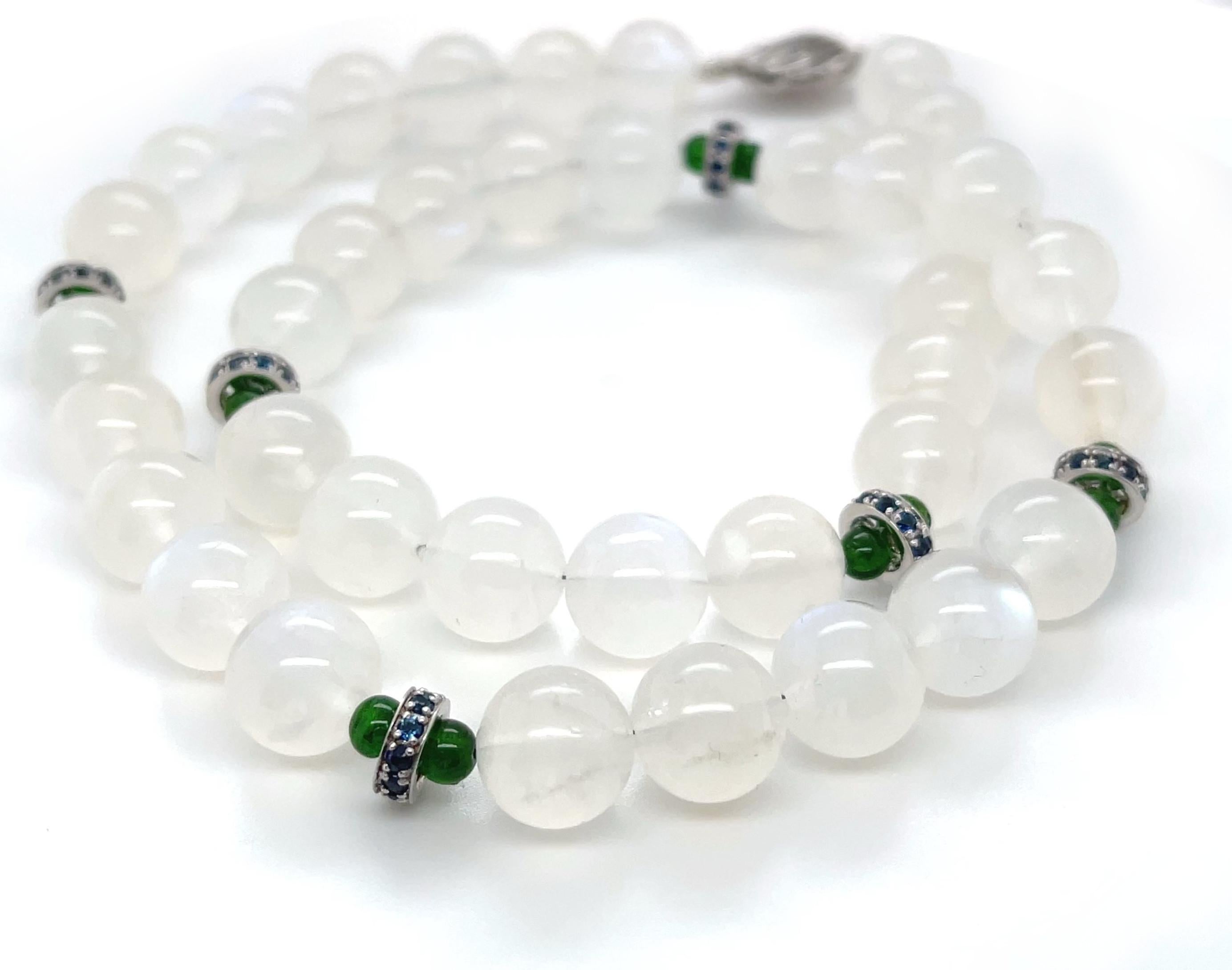 This lovely necklace features beautifully matched  moonstone beads arranged with bright green chrome diopside and accented with blue sapphire studded rondels. The 10mm moonstone beads have gorgeous 