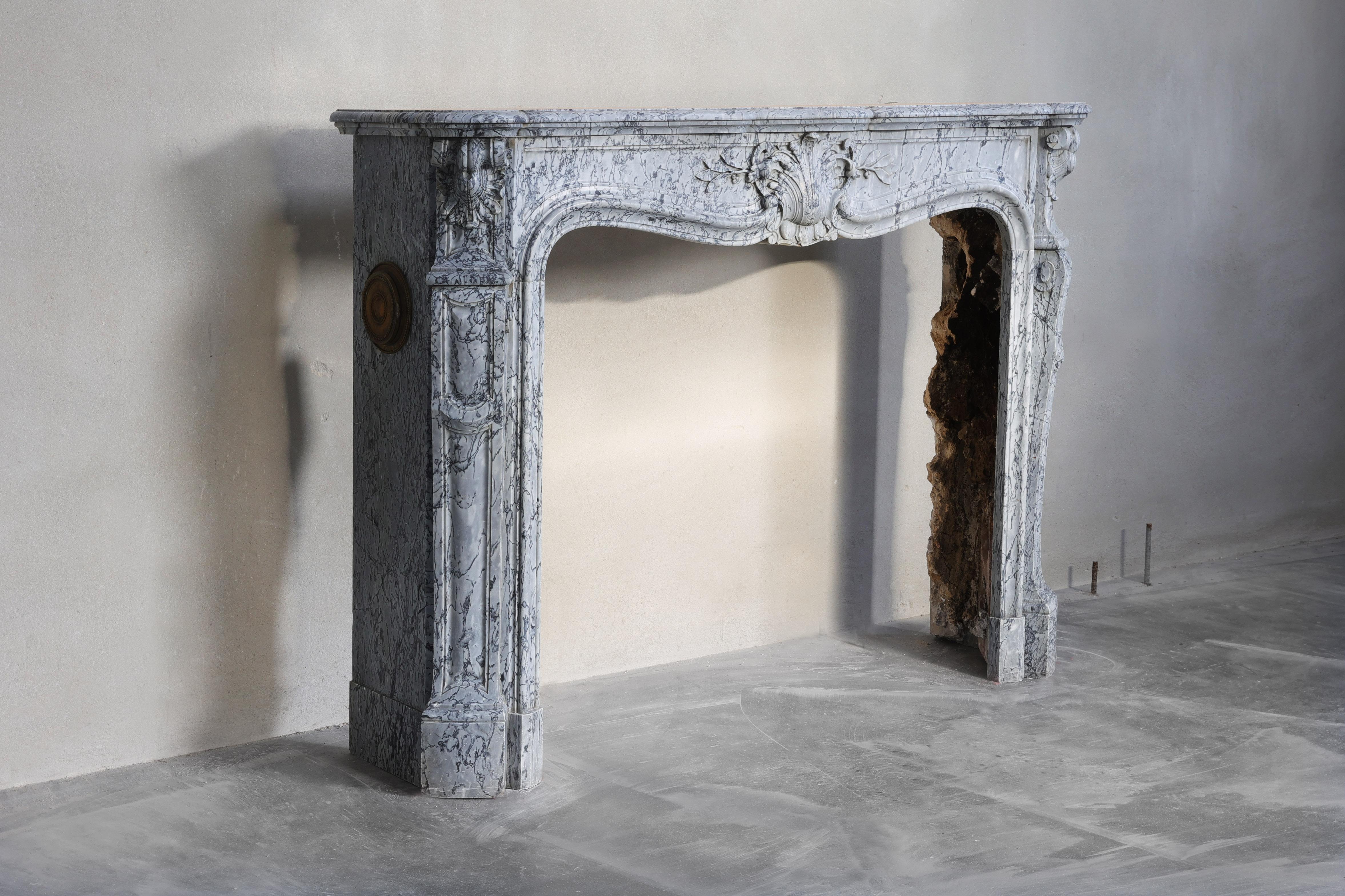 A beautiful antique fireplace made of blue fleuri marble from Italy. This type of marble is mined in Seravezza in Tuscany. Bleu Fleuri marble takes its name from the freshness of the shade and has a delicate color, with many veins of various types.