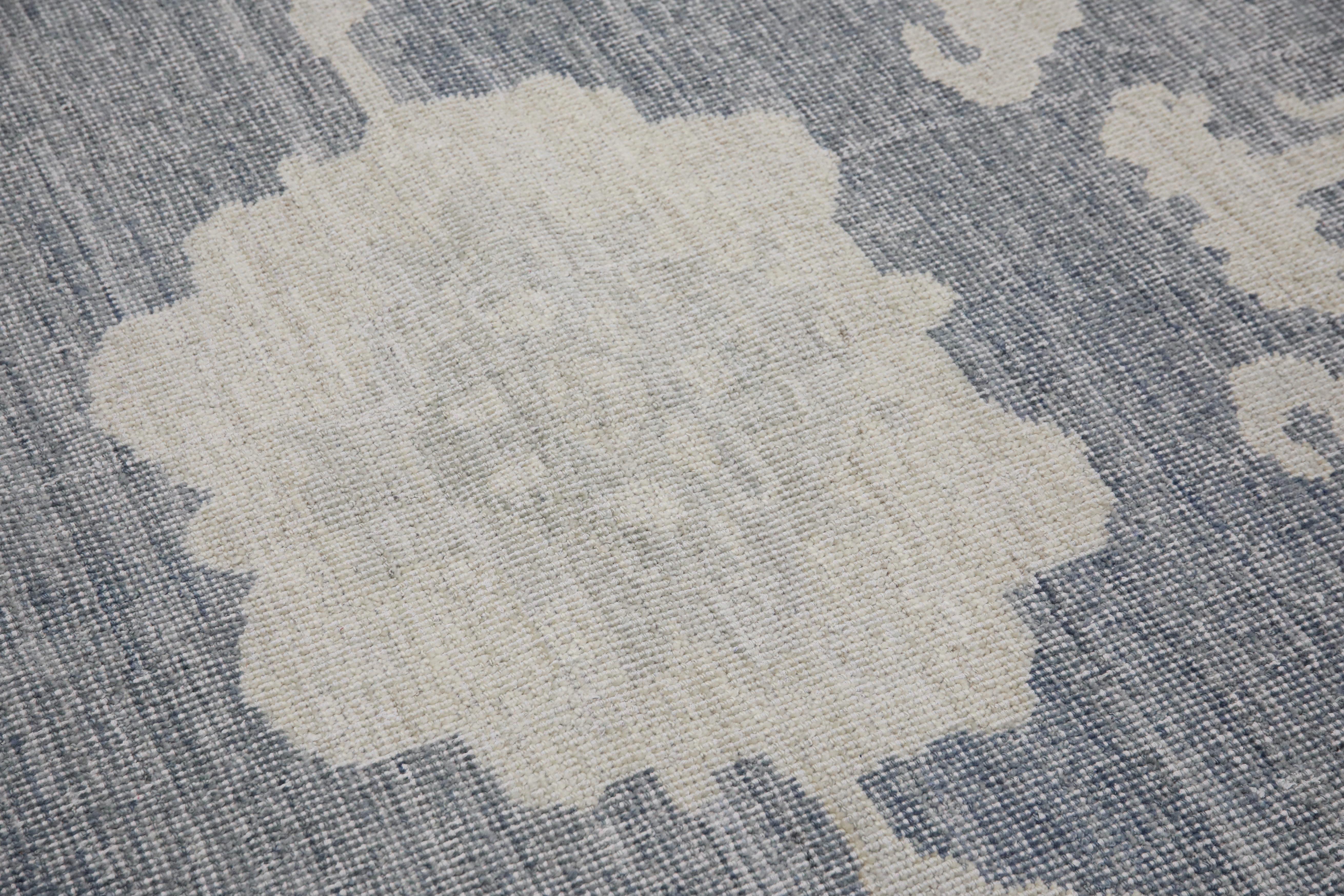 This modern Turkish Oushak rug is a stunning piece of art that has been handwoven using traditional techniques by skilled artisans. The rug features intricate patterns and a soft color palette that is achieved through the use of natural vegetable