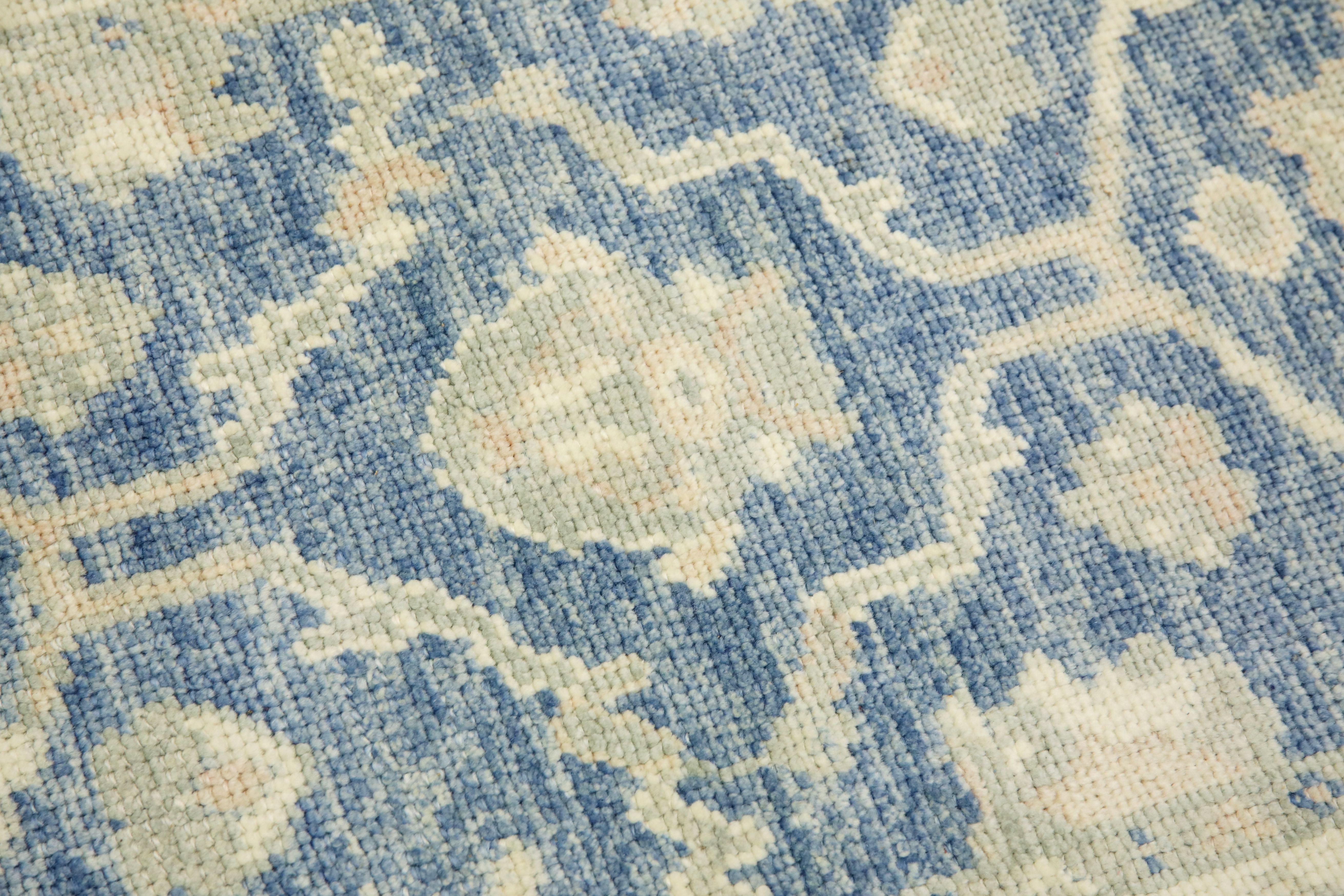 This modern Turkish Oushak rug is a stunning piece of art that has been handwoven using traditional techniques by skilled artisans. The rug features intricate patterns and a soft color palette that is achieved through the use of natural vegetable